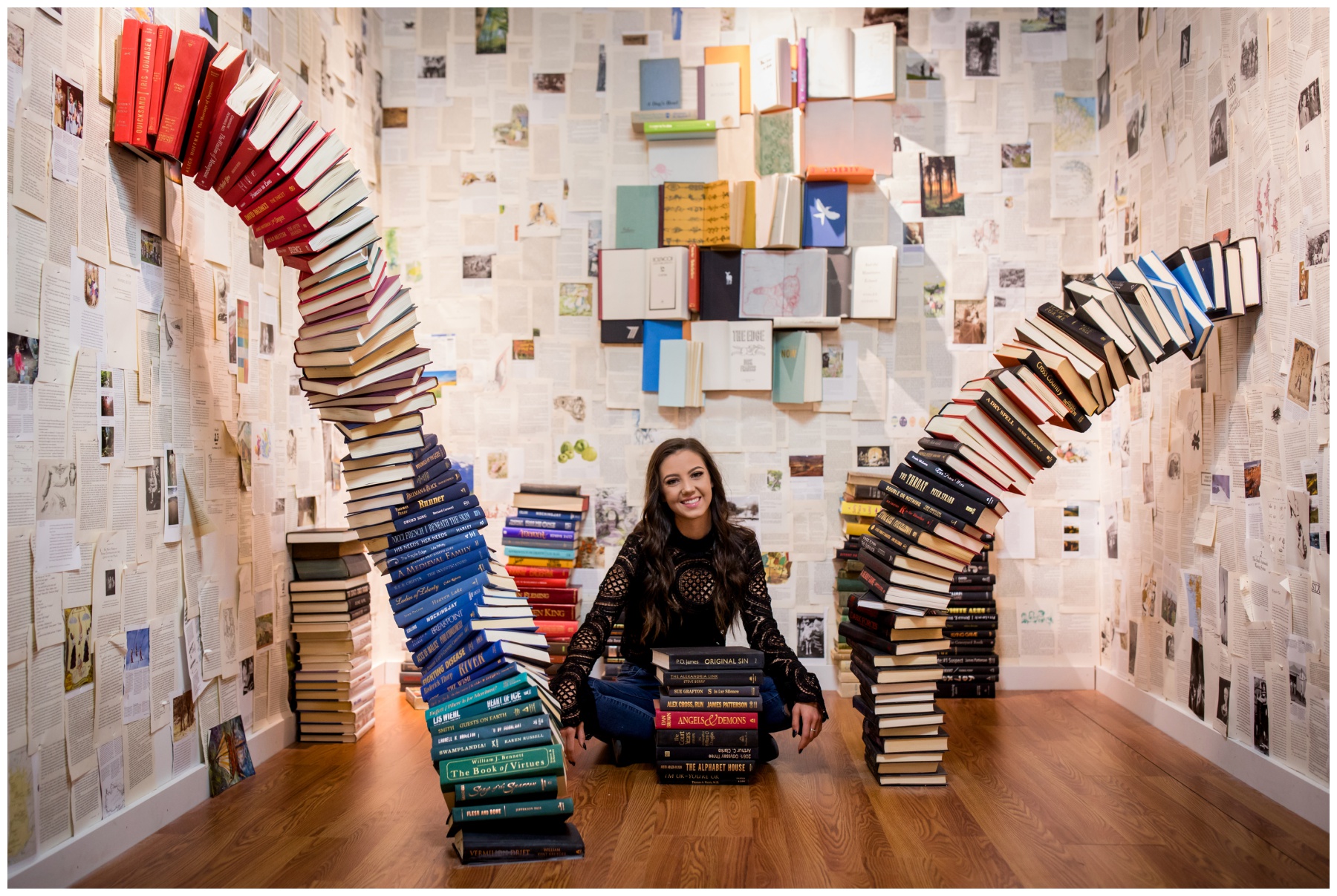 teen girl sitting in room full of books during unique Boulder Colorado senior photography session 