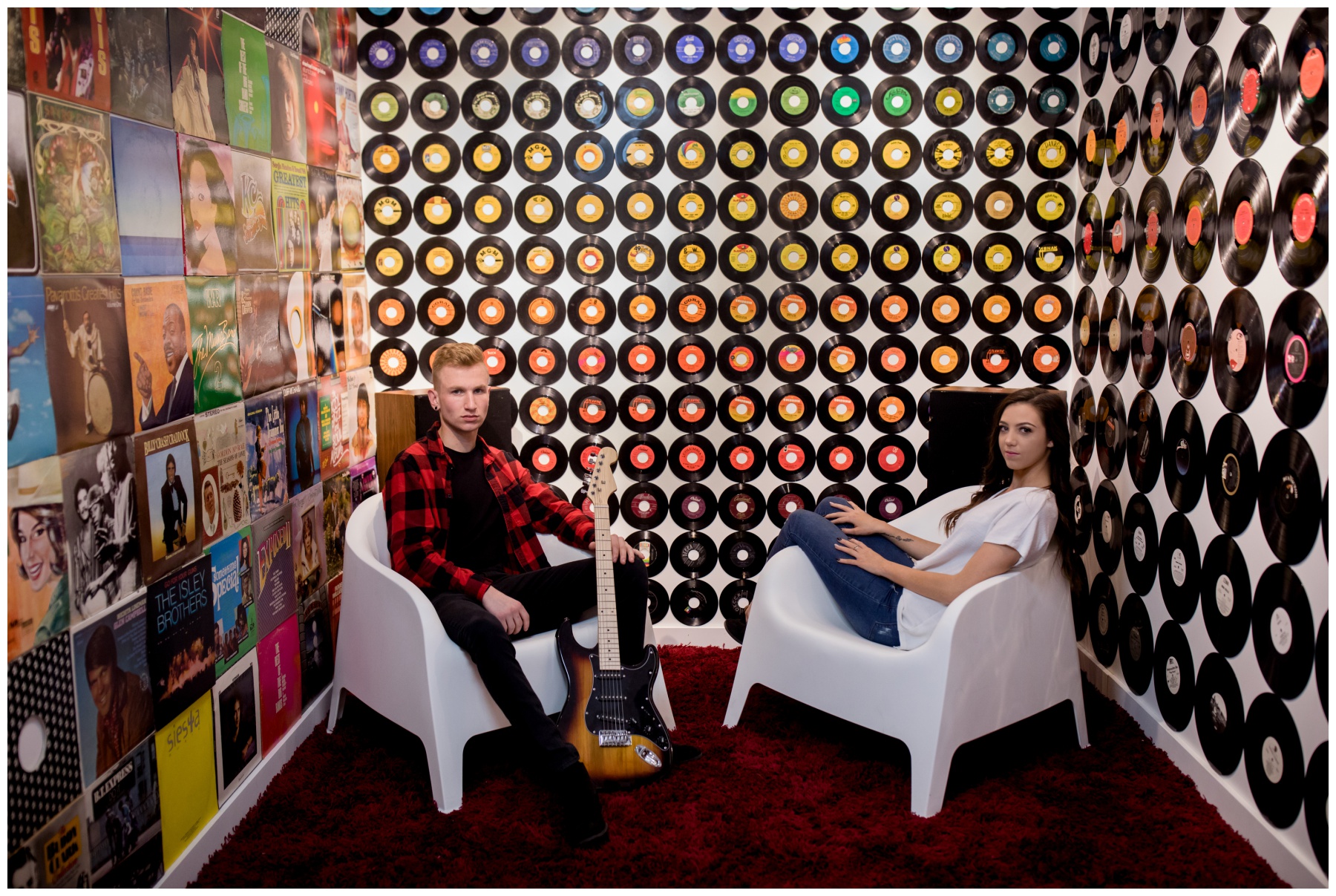 young couple posing in music room with records and a guitar at Wonder Wonder CO