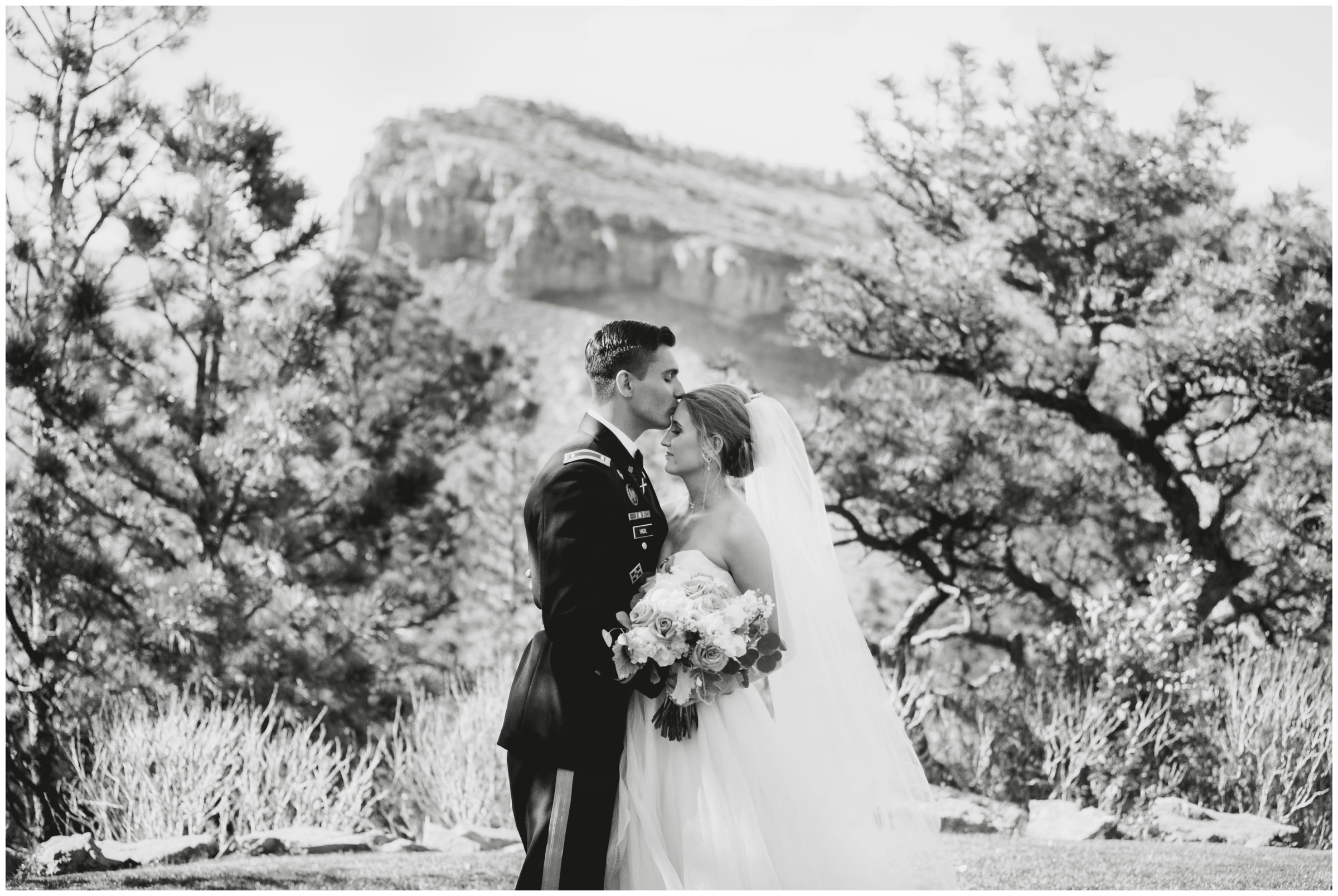 military groom kissing bride on forehead at Lyons Colorado wedding