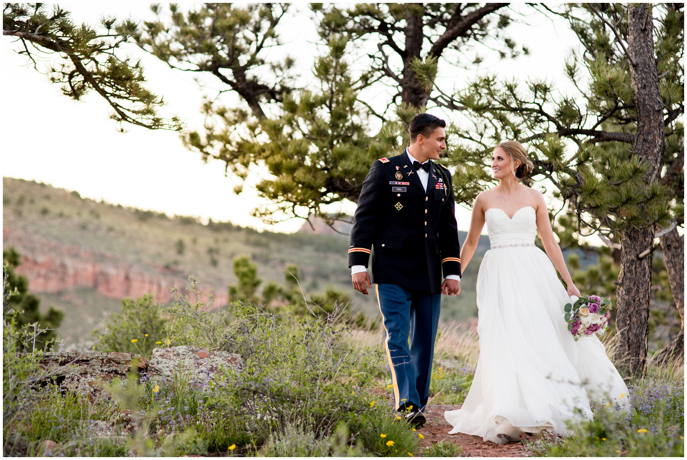 bride and groom walking with mountains in background during Colorado summer wedding photos