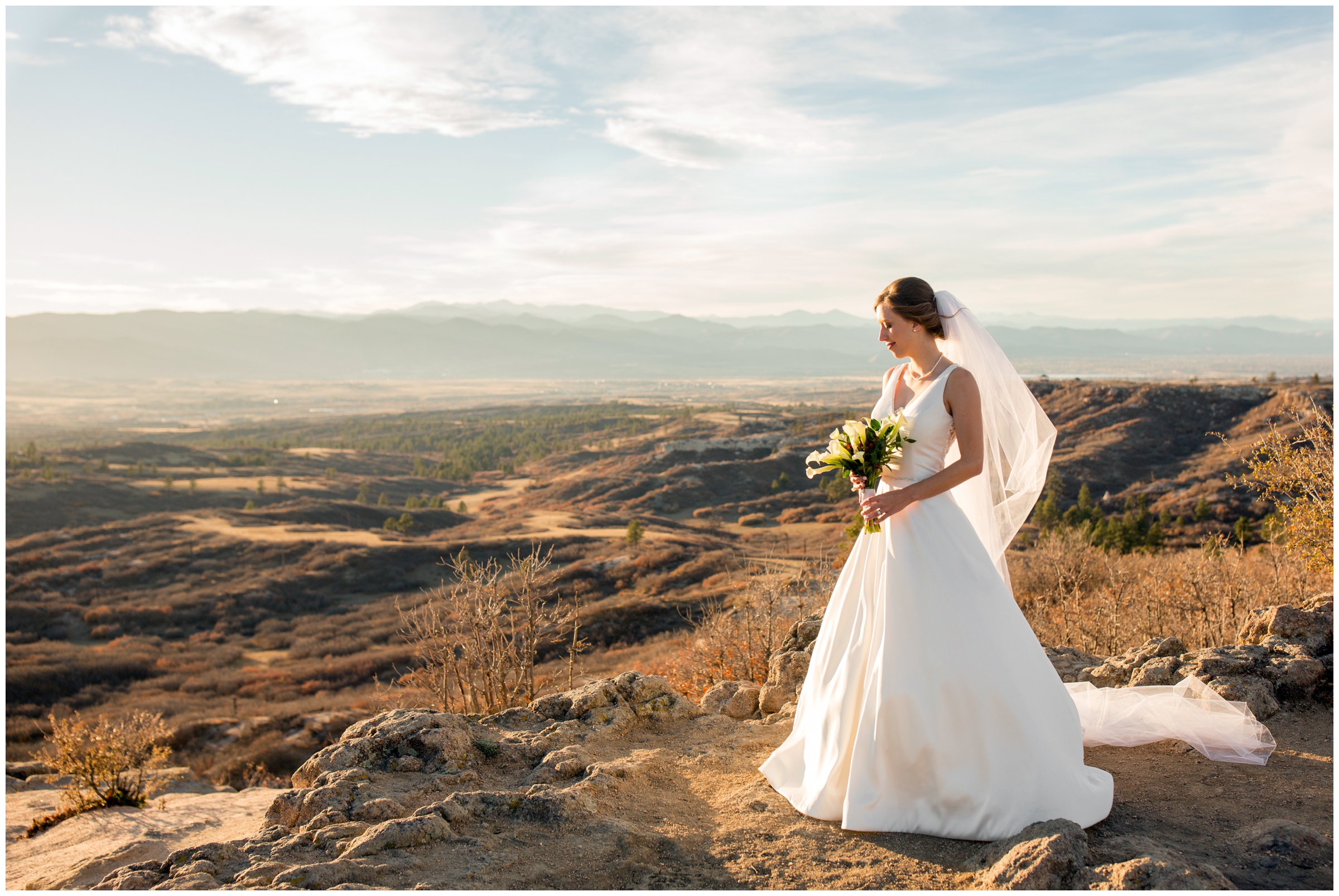 bride standing on edge of rock cliff during Daniels Park Colorado wedding portraits 