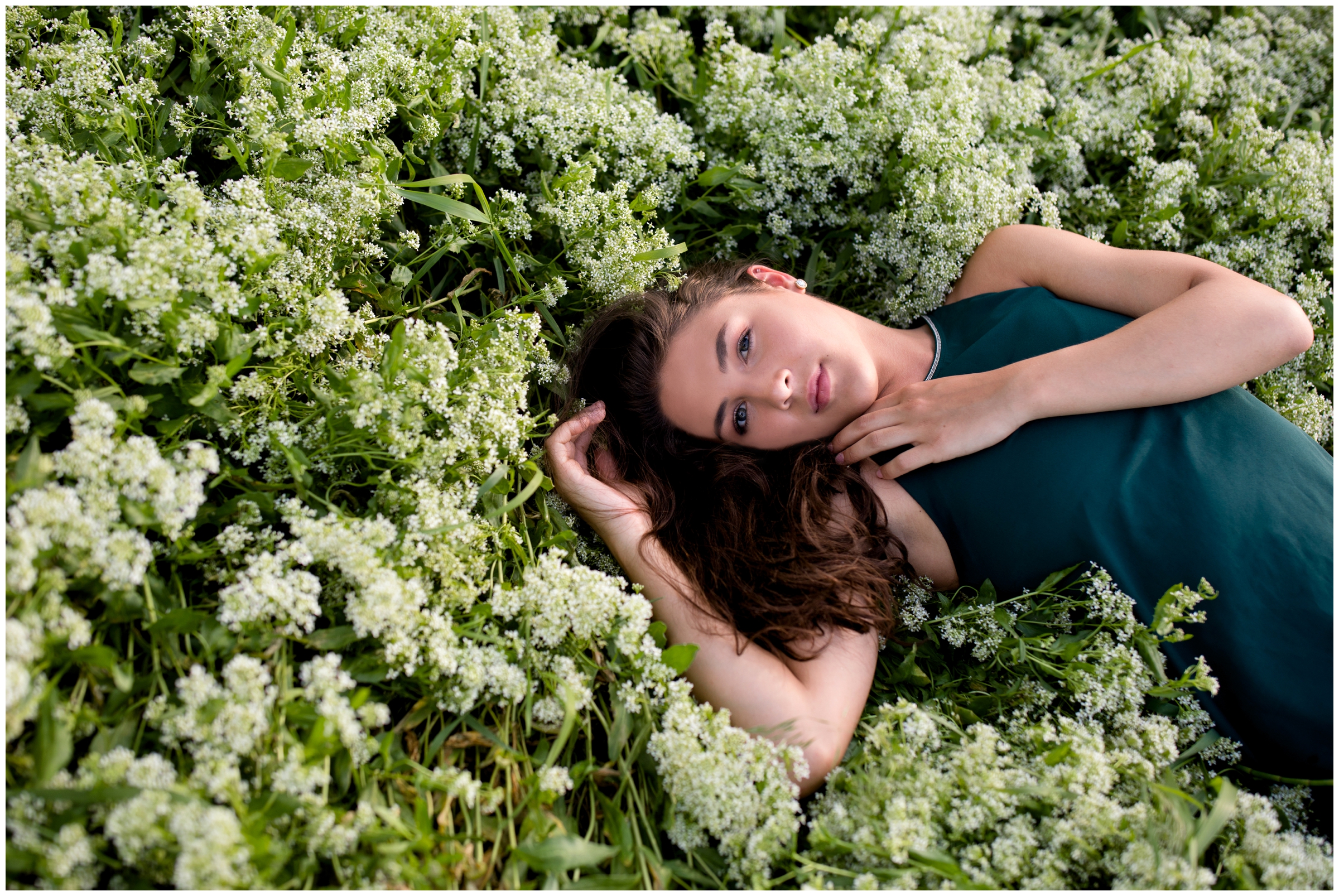 teen laying in flowers during Erie Colorado senior portraits by Longmont photographer Plum Pretty Photography