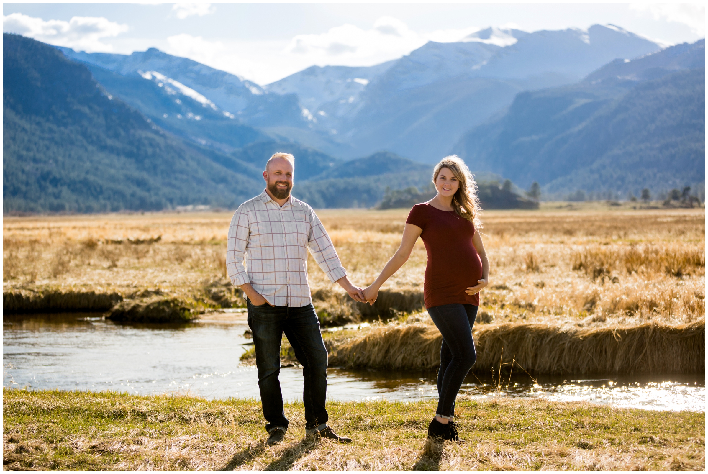 couple holding hands with mountains in background during Estes Park maternity pictures at Moraine Park RMNP