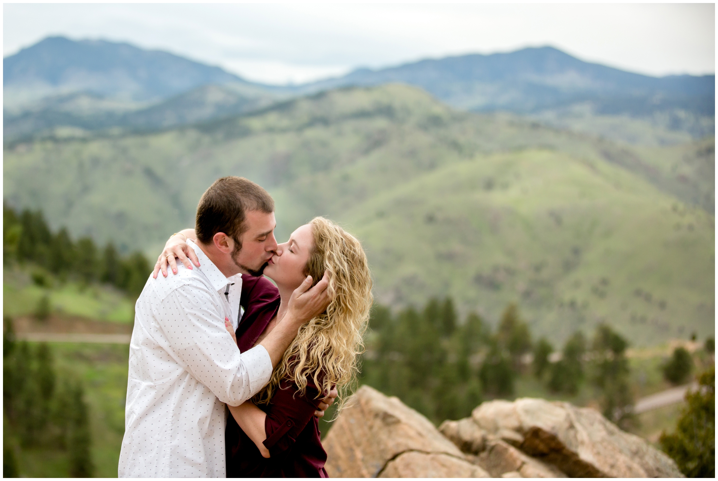 couple kissing with mountains in background during Golden Colorado engagement pictures 