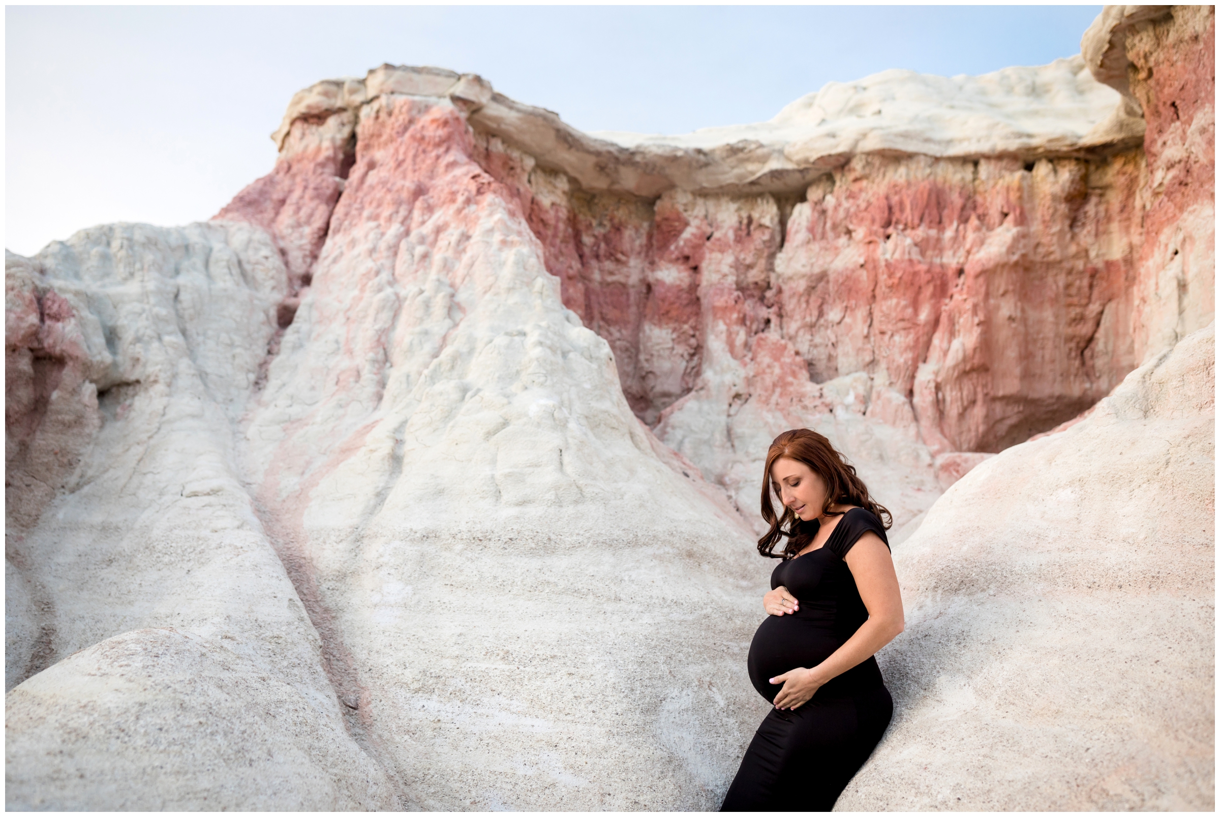 woman sitting on rock formations during Paint Mines Colorado maternity photos
