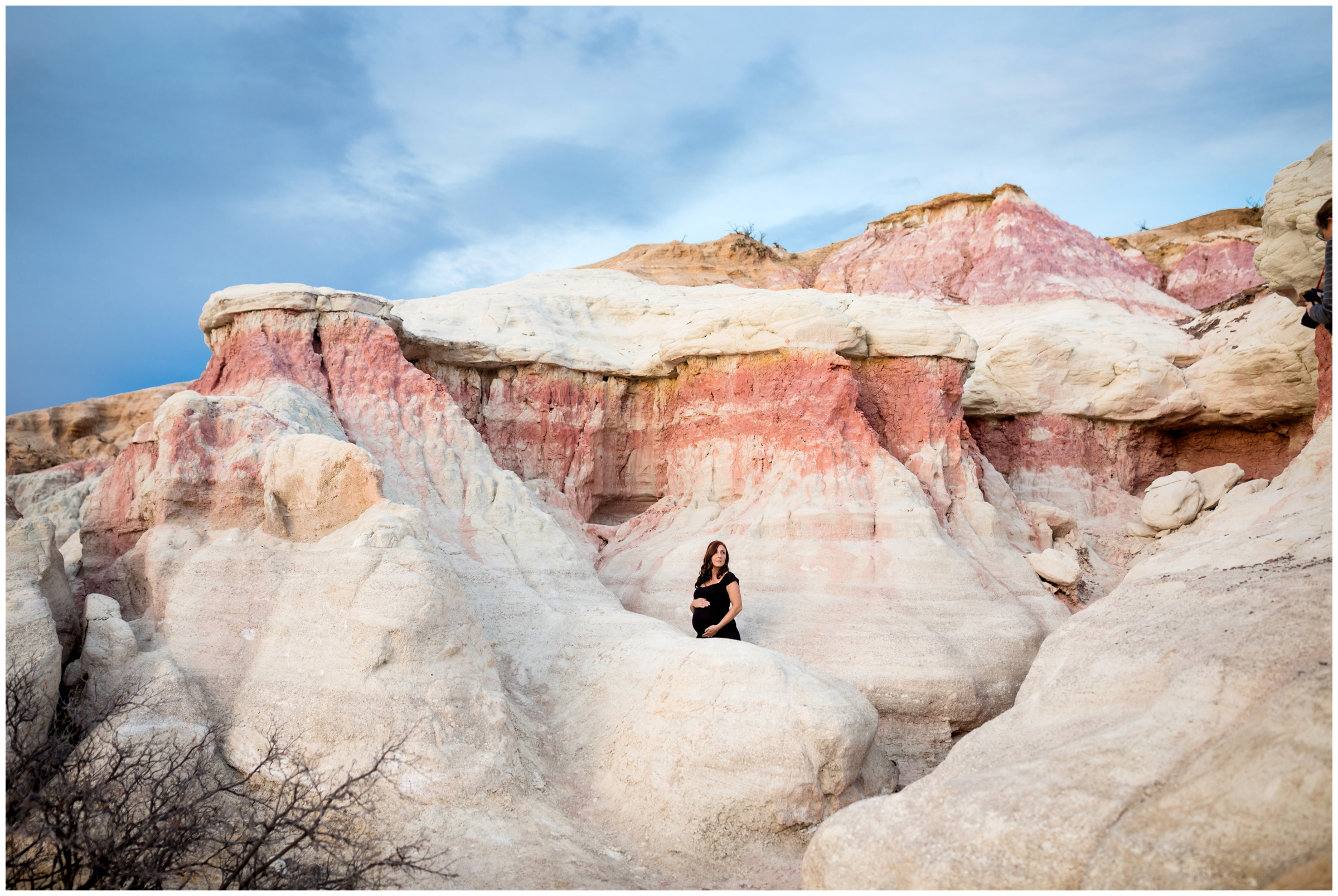 pregnant woman standing amongst rock formations during maternity photography session at Paint Mines Colorado 