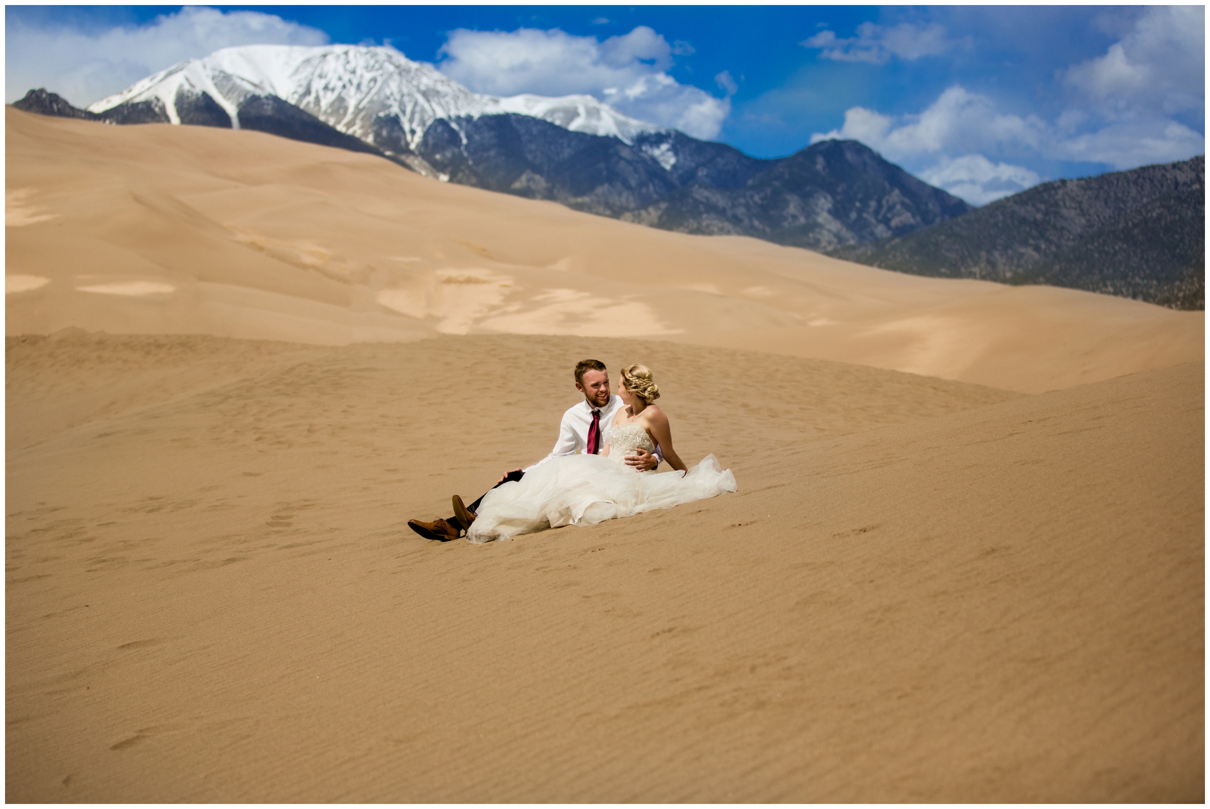 couple sitting on the sand dunes during Colorado adventure elopement 