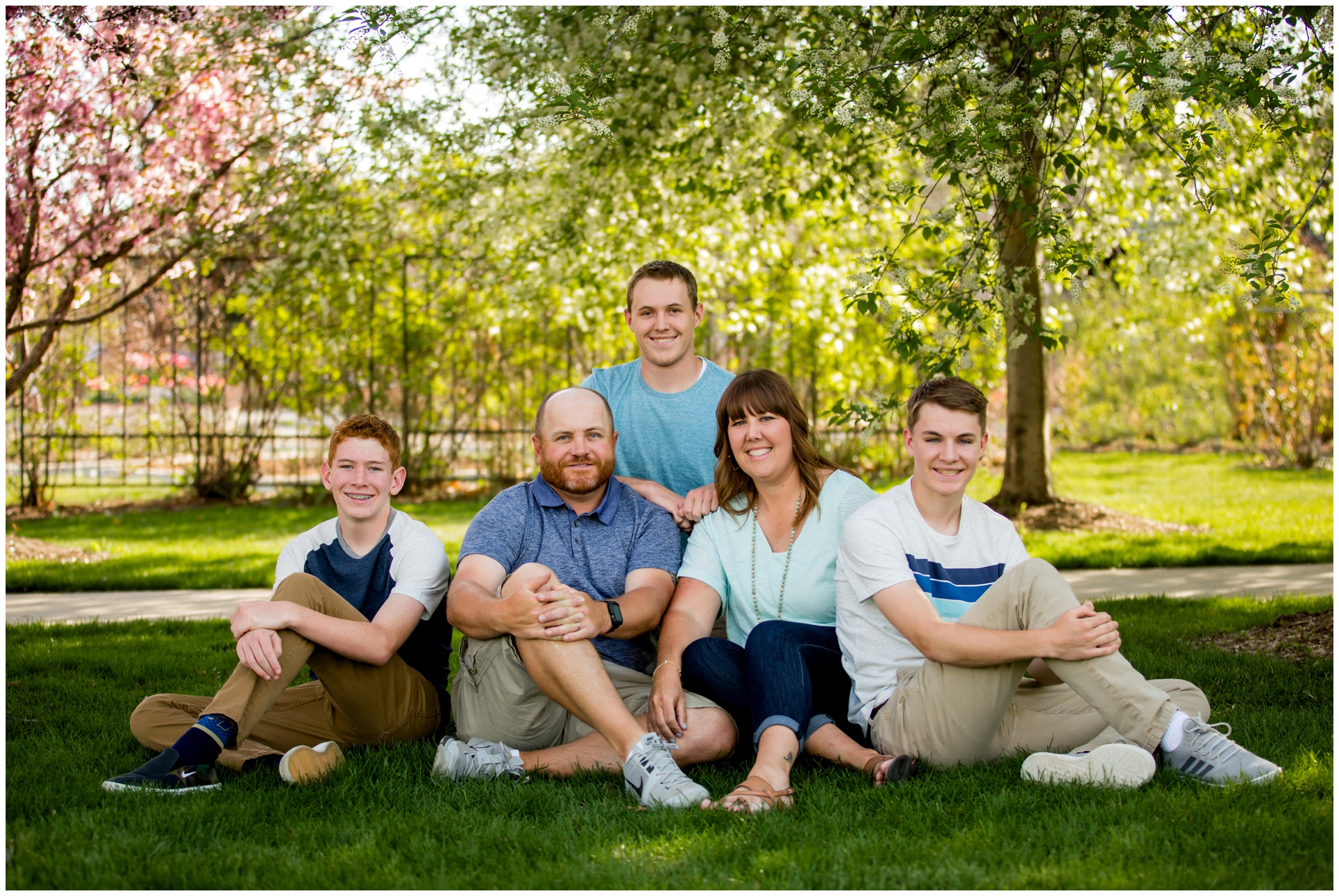 family of five sitting in the grass during Colorado family photography session