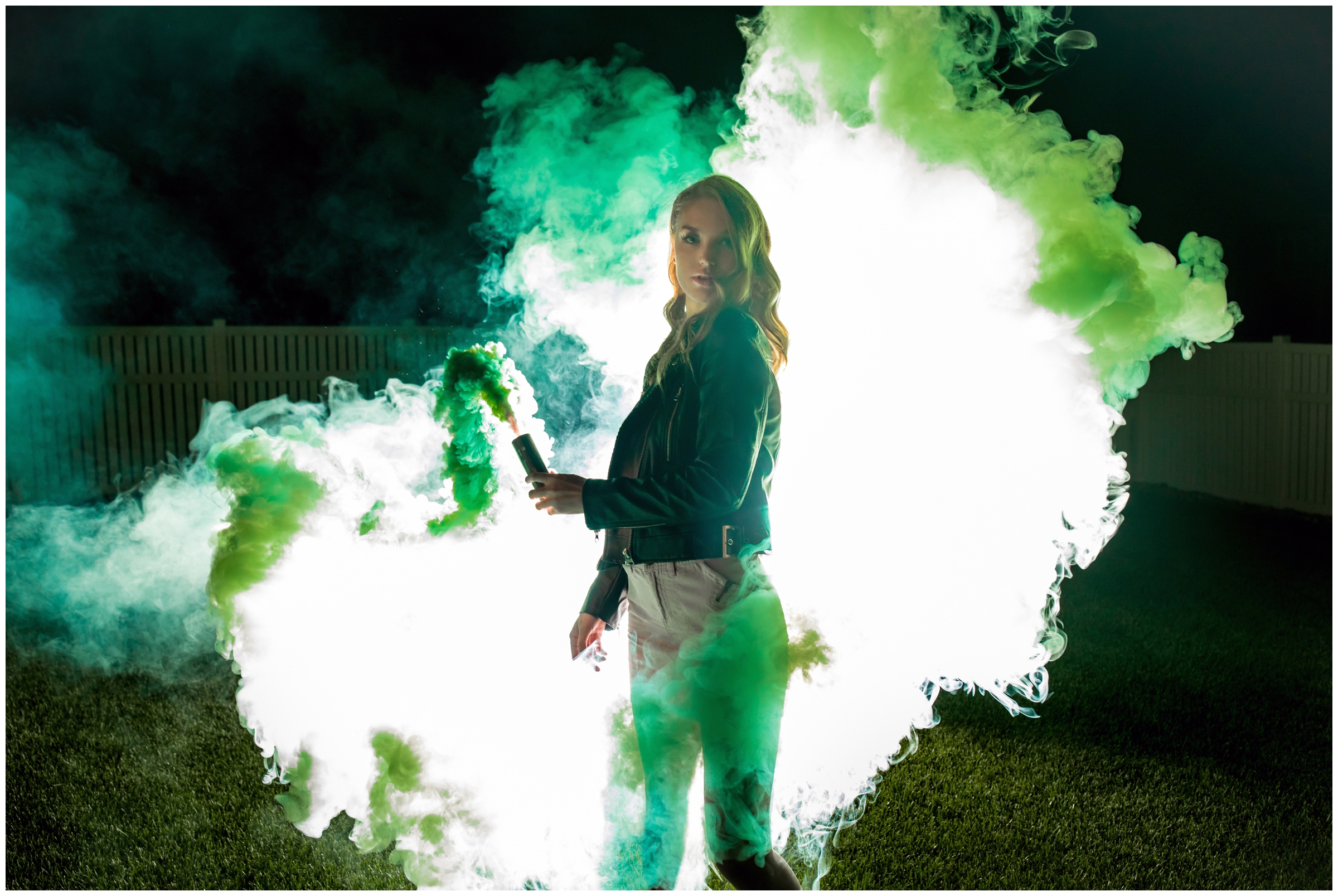 teen posing with green smoke bomb during nighttime senior pictures in Firestone, Colorado