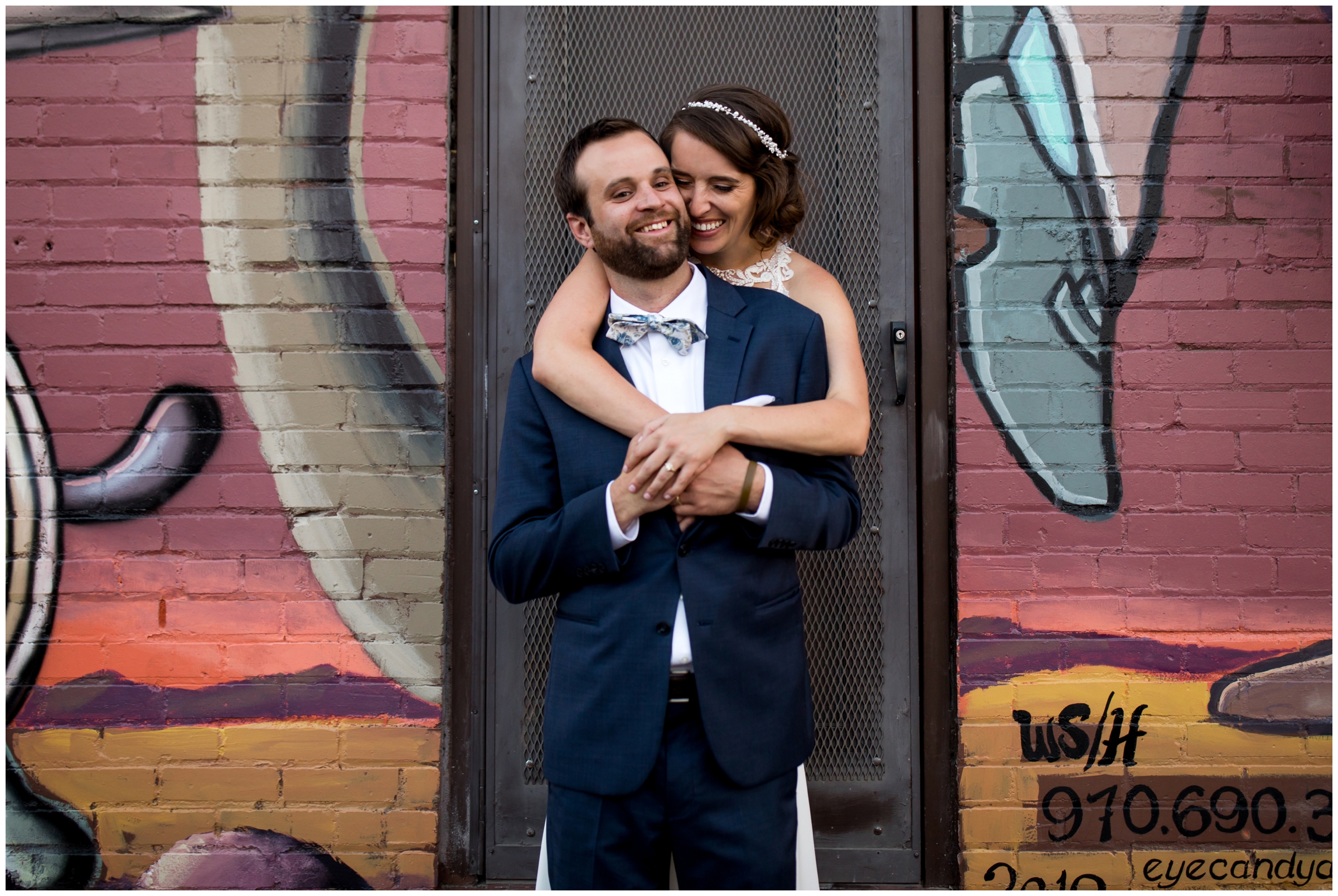 wedding couple cuddling in front of graffiti wall in Ft. Collins Colorado 