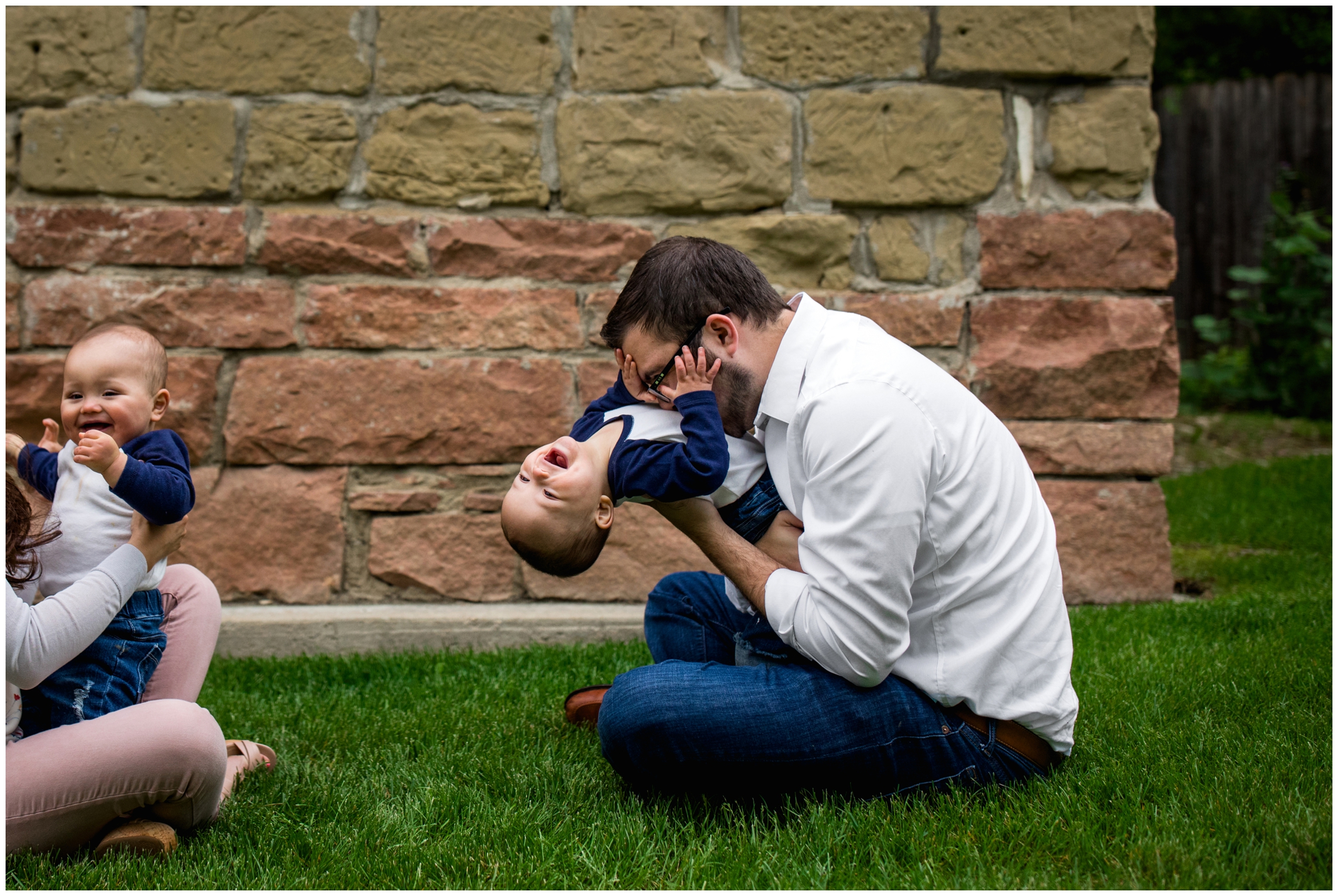 dad tickling son during Longmont Colorado family pictures at Old mill park 