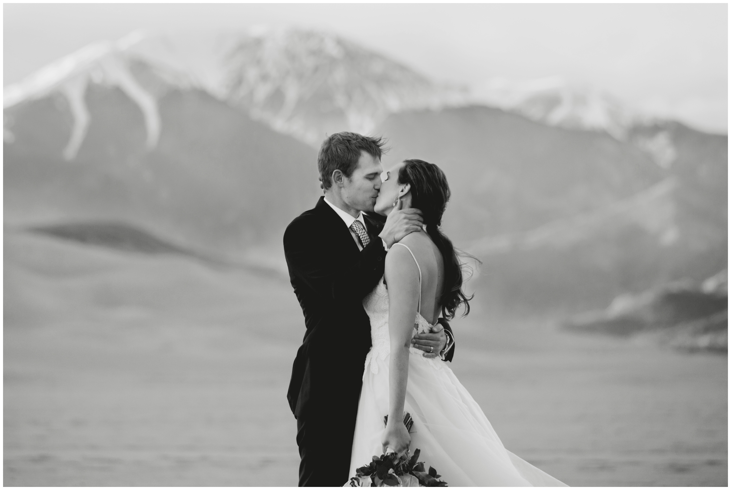 couple kissing with mountains in background during Colorado spring elopement portraits 