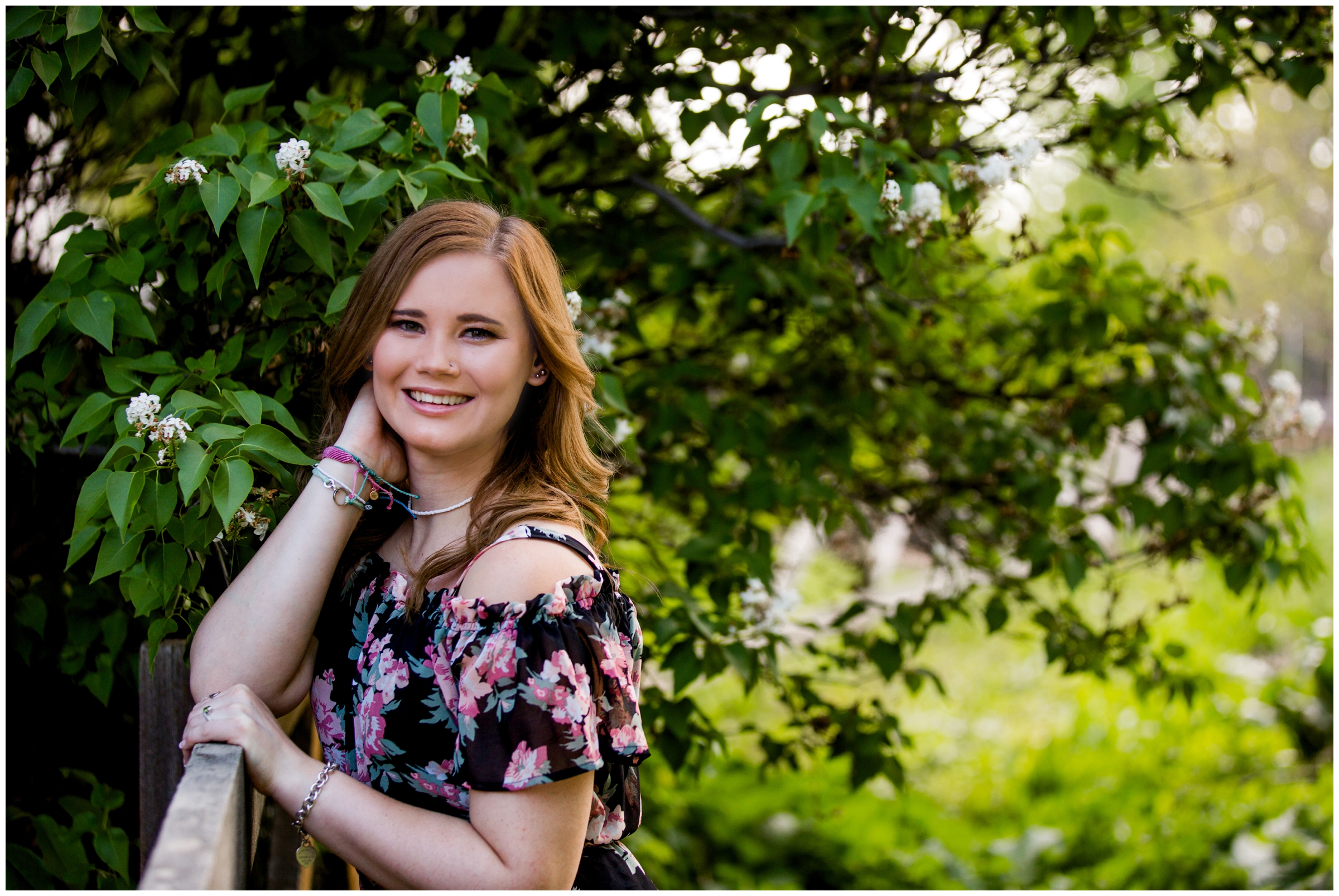 teen leaning against a fence during Erie High senior pictures by Colorado portrait photographer Plum Pretty Photography