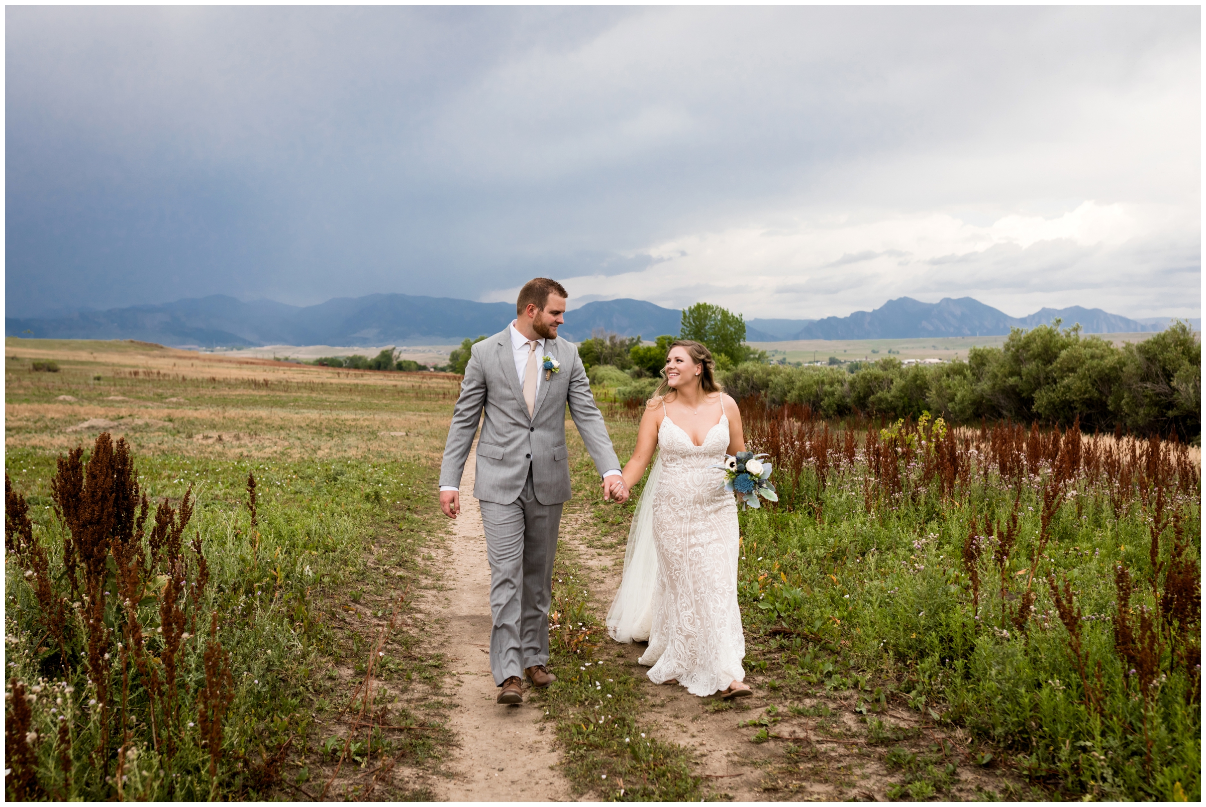 couple walking with mountains in background before Noah's event center Colorado wedding
