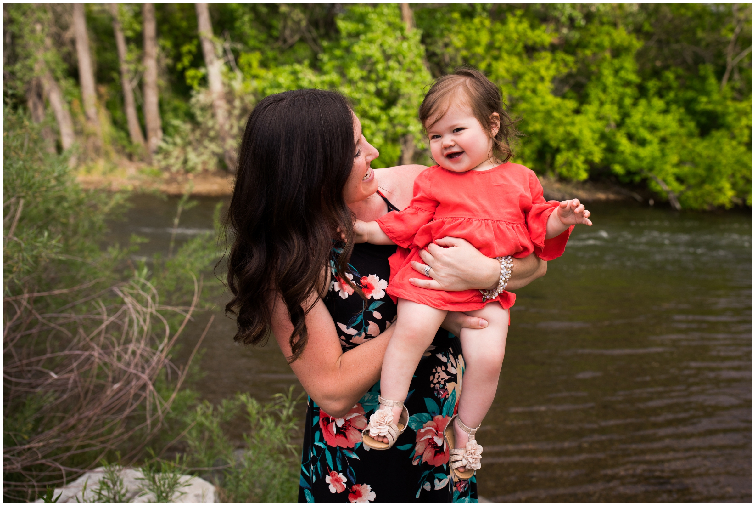 mom holding daughter by river during Colorado children photos 