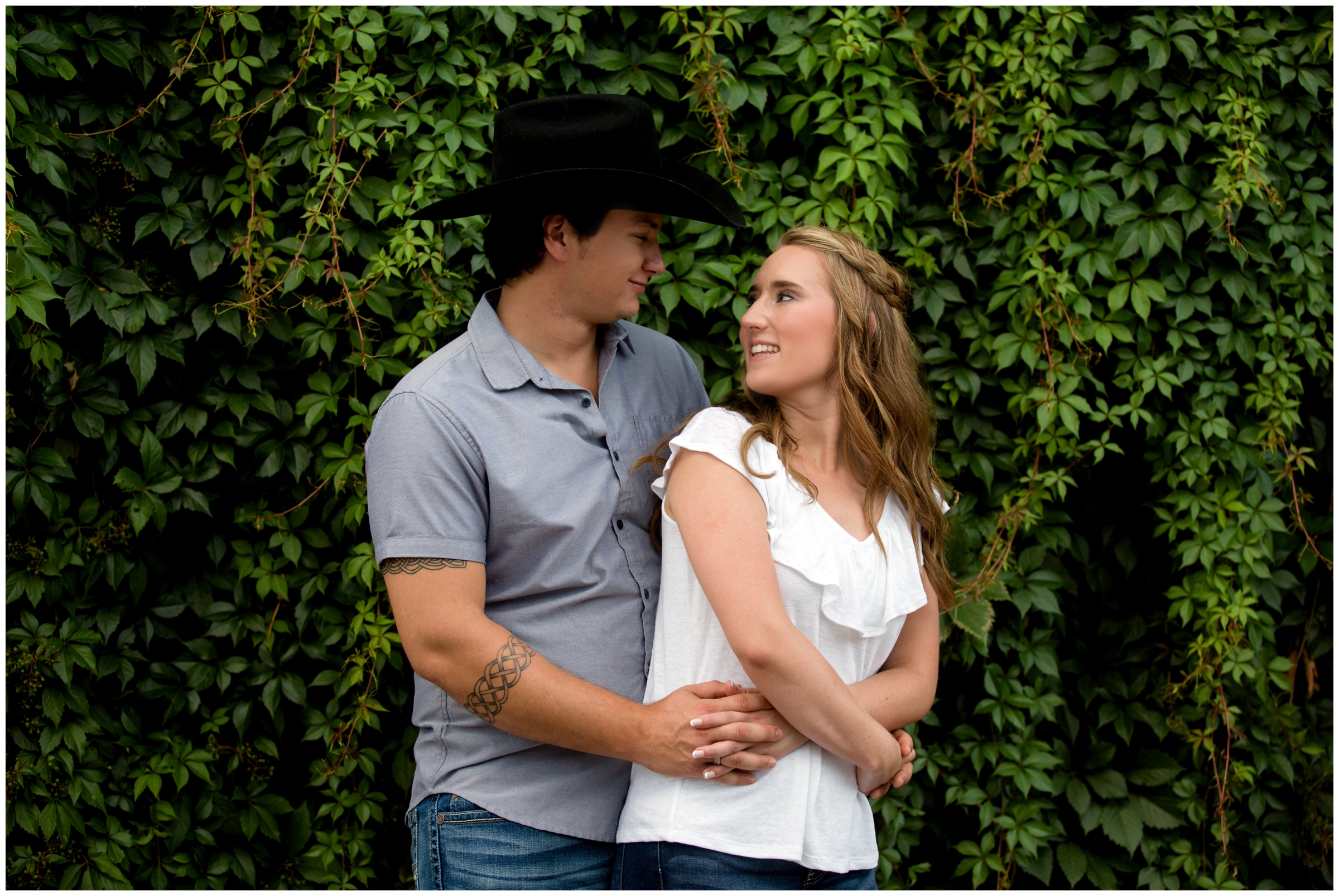 couple posing in front of ivy wall during Fort Collins engagement portraits 