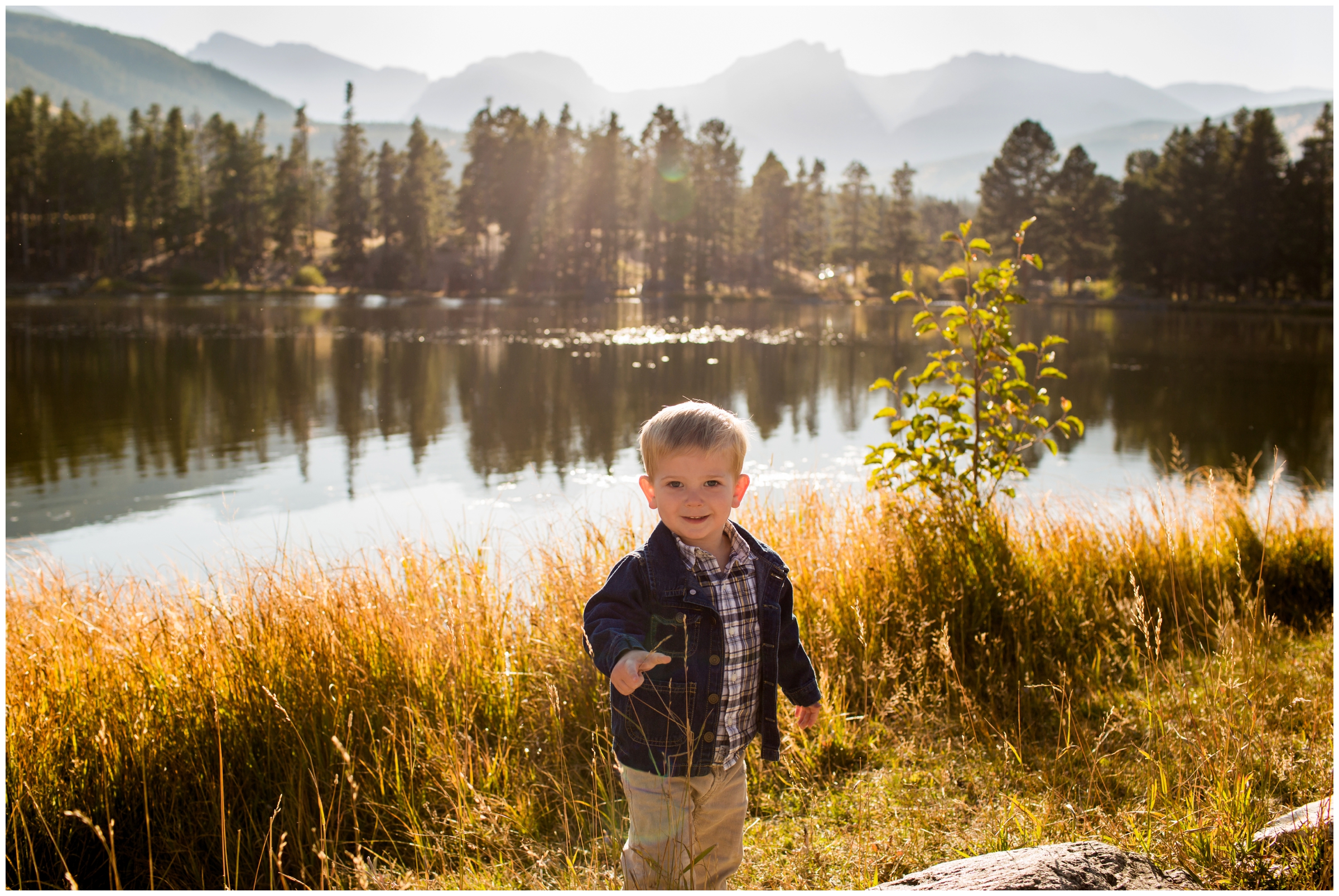 little boy standing in front of Sprague Lake in RMNP 