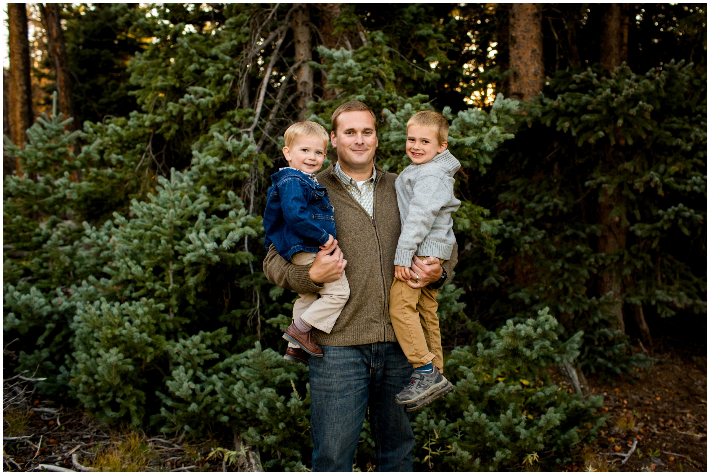 dad holding sons during Colorado forest family photos 