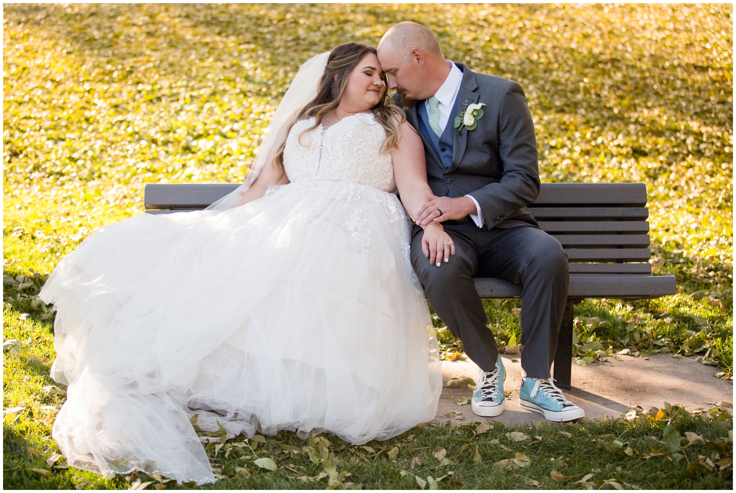 bride and groom cuddling on bench during Colorado fall wedding portraits 