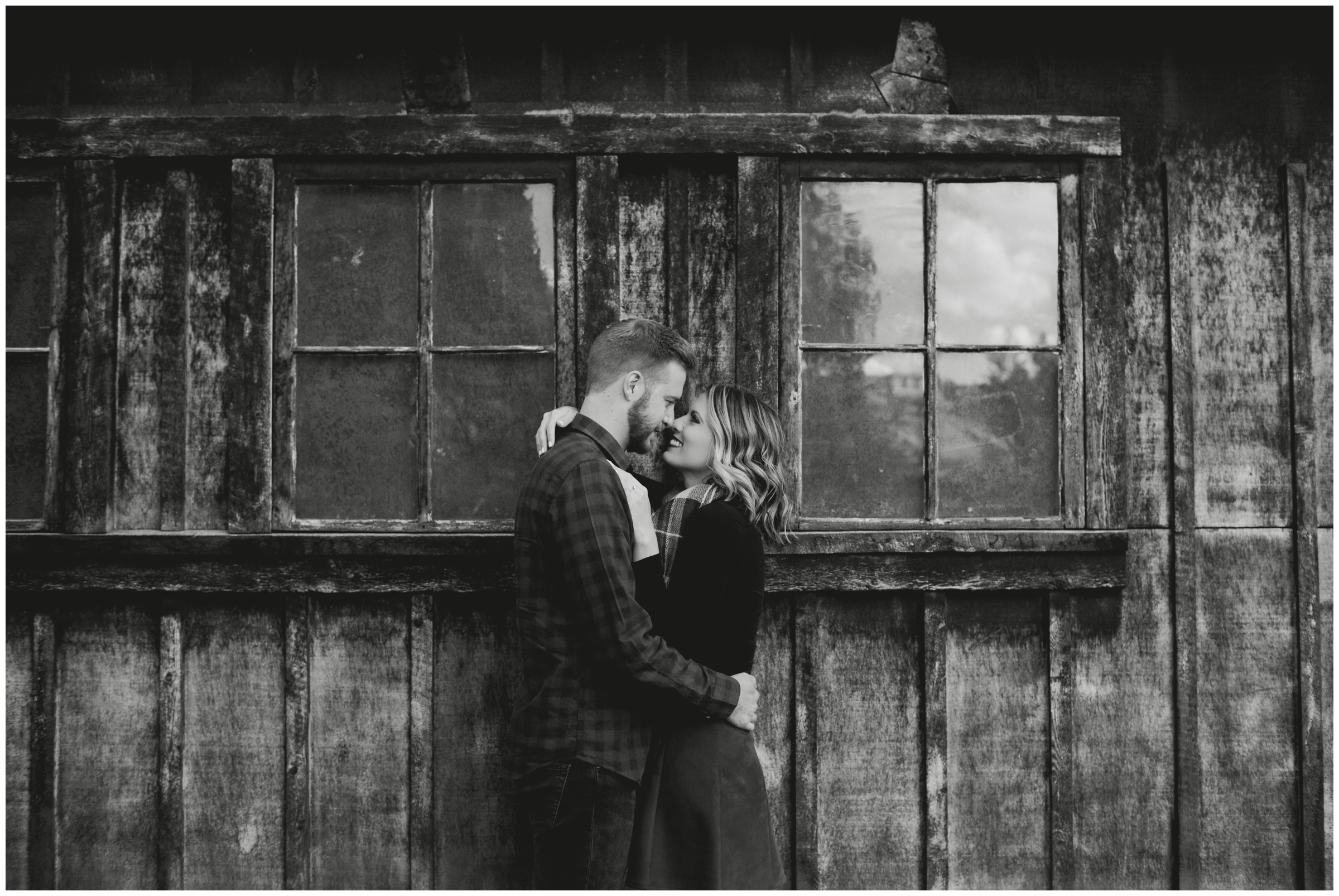 couple posing in front of rustic barn at Colorado mountain engagement portraits