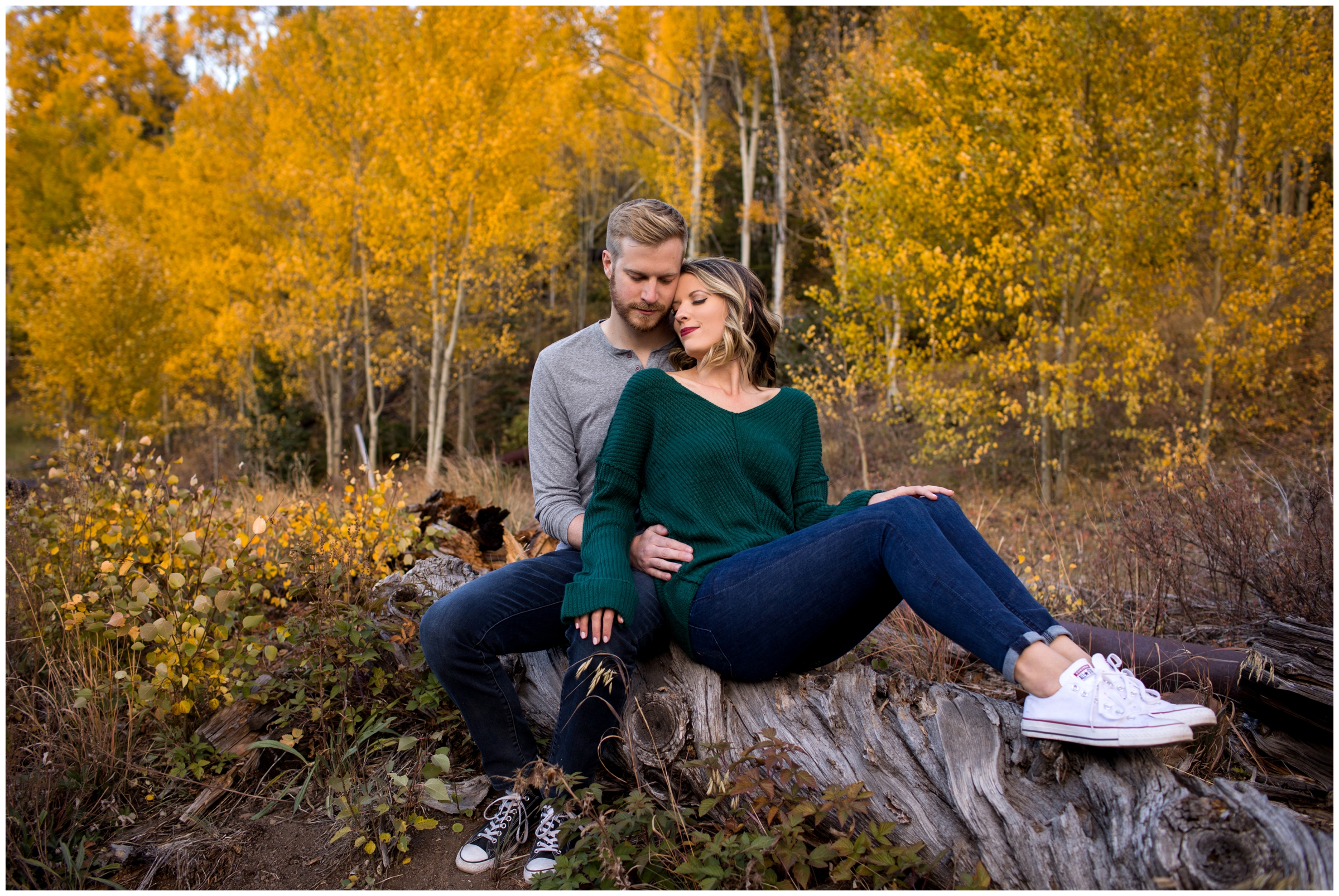 couple sitting on tree stump during Colorado mountain engagement portraits