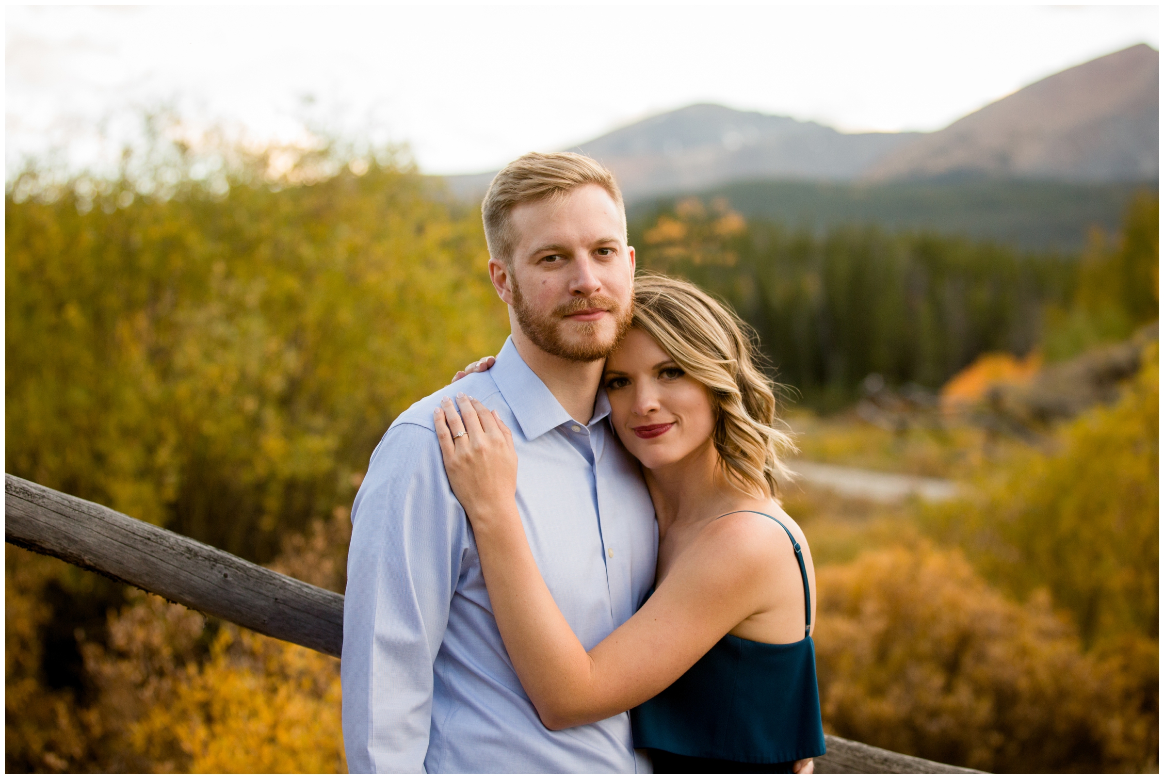 couple embracing with mountains in background during Colorado fall engagement pictures 