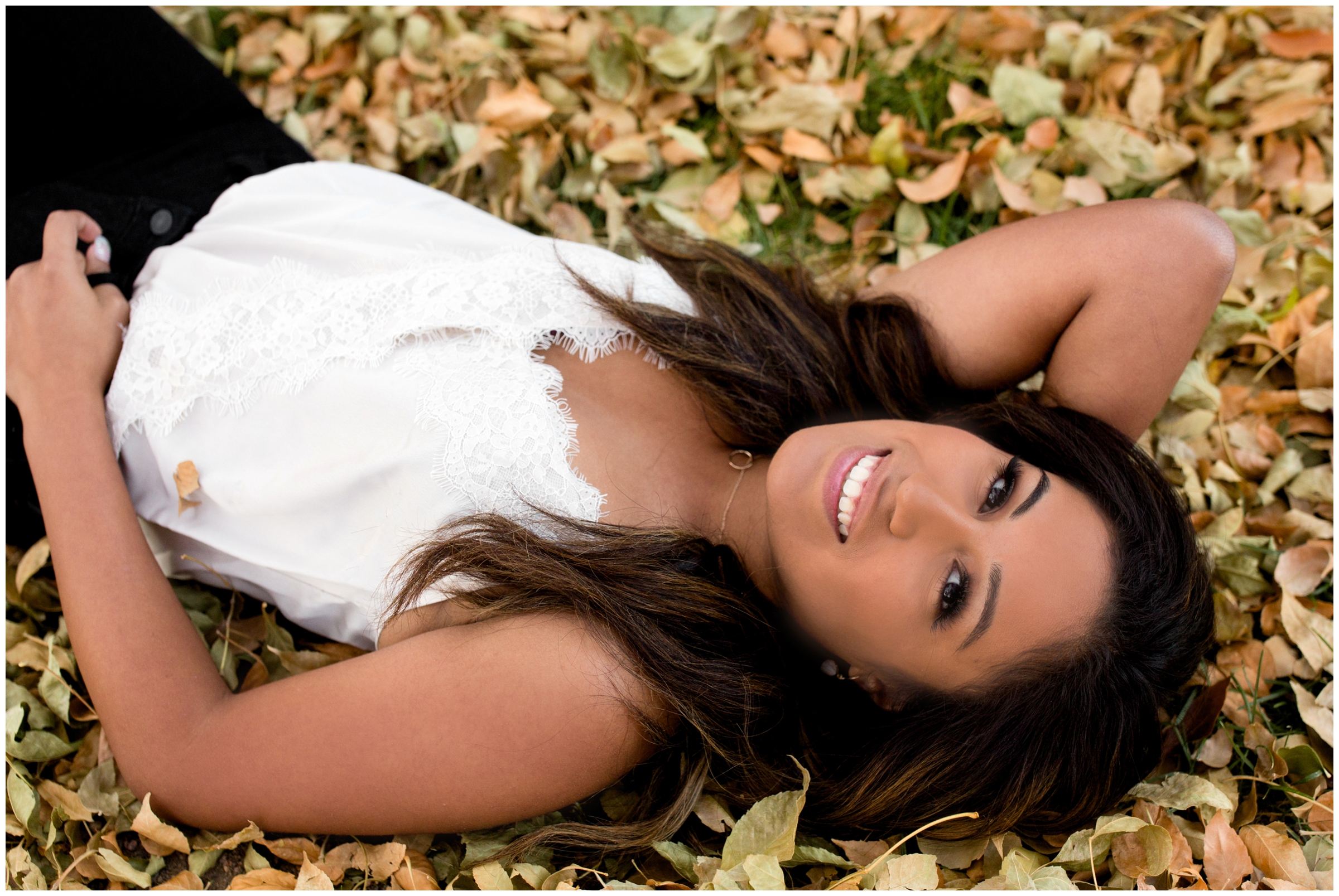 Frederick High School student laying in leaves during fall Colorado senior photos 