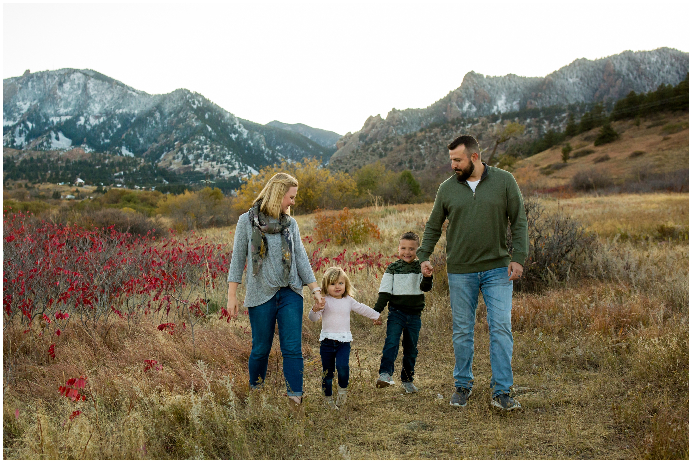 family walking through field at South Mesa Trail during Colorado fall family portraits 