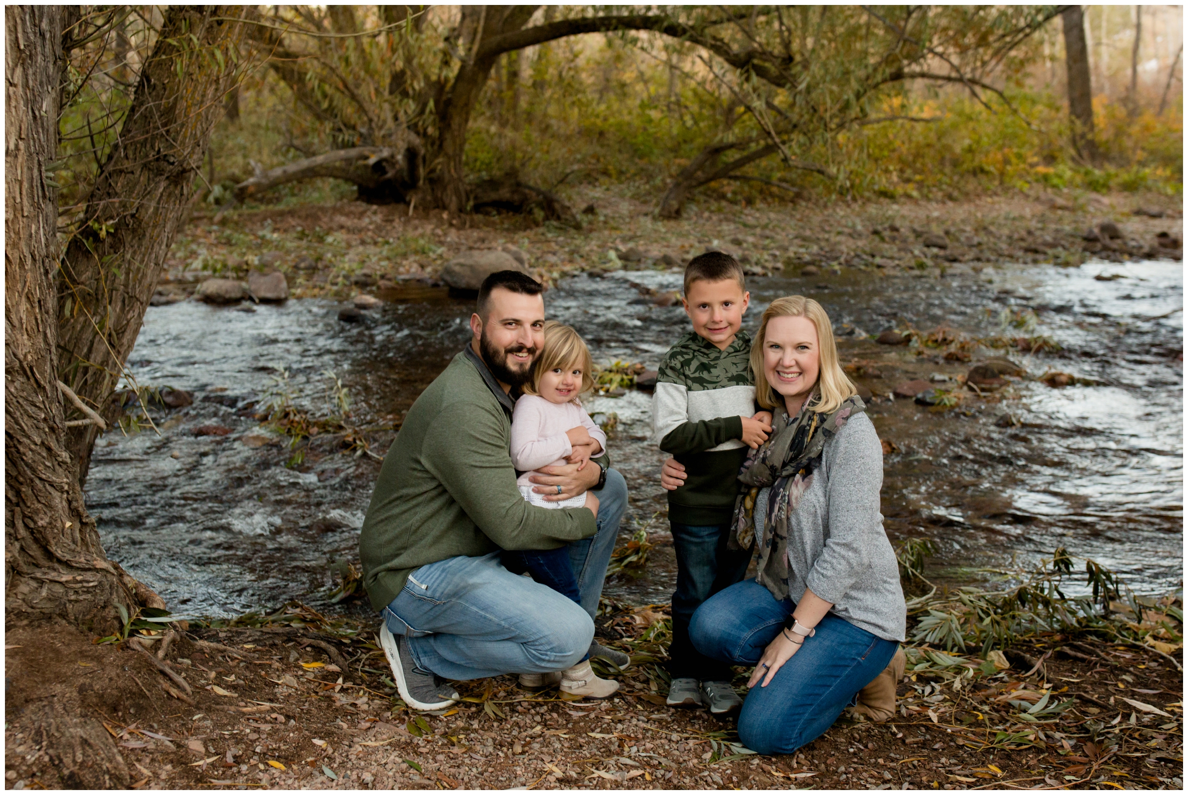 family posing next to river during Colorado fall portraits at South Mesa trail 