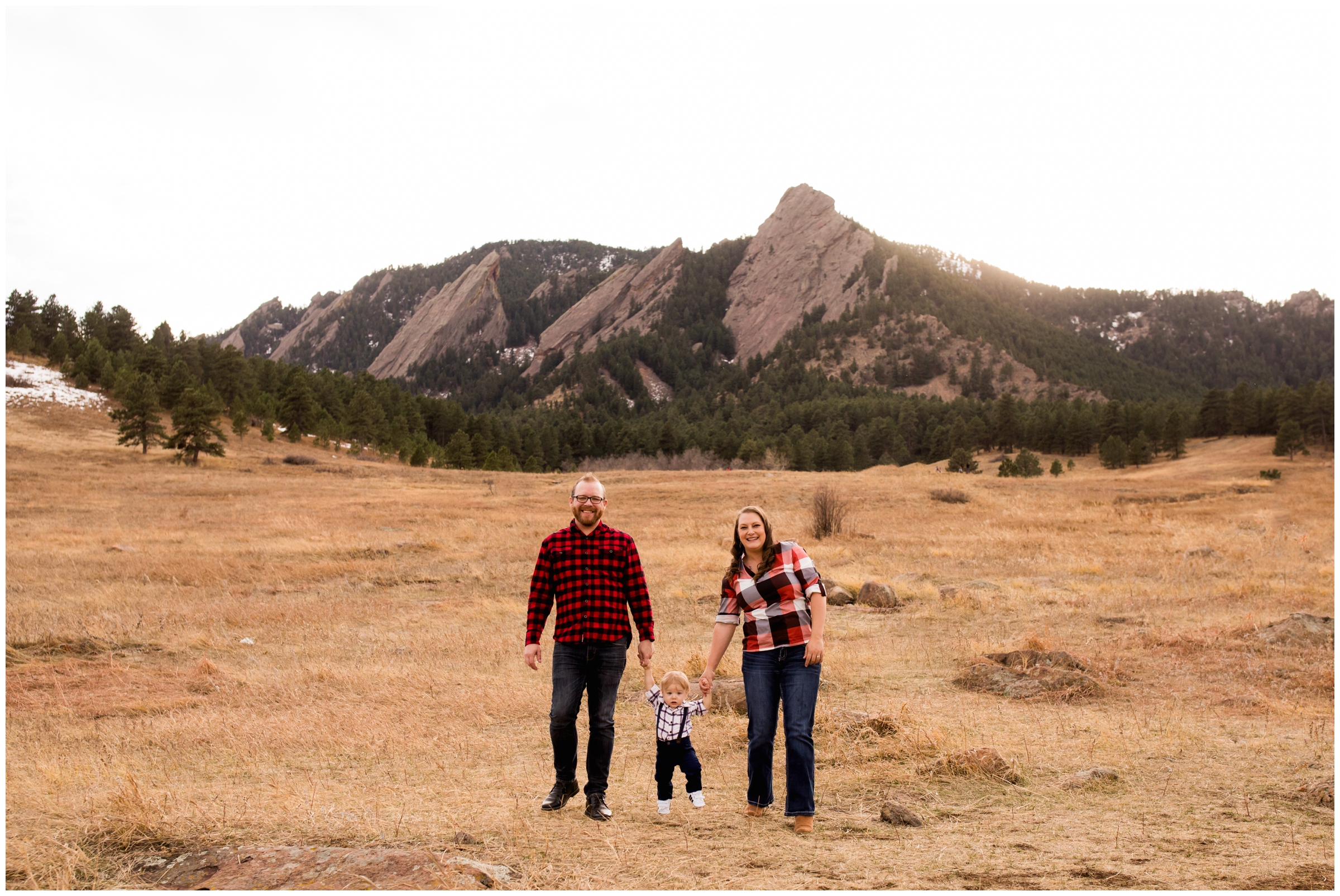 family walking through field with mountains in background during Boulder Colorado family pictures 