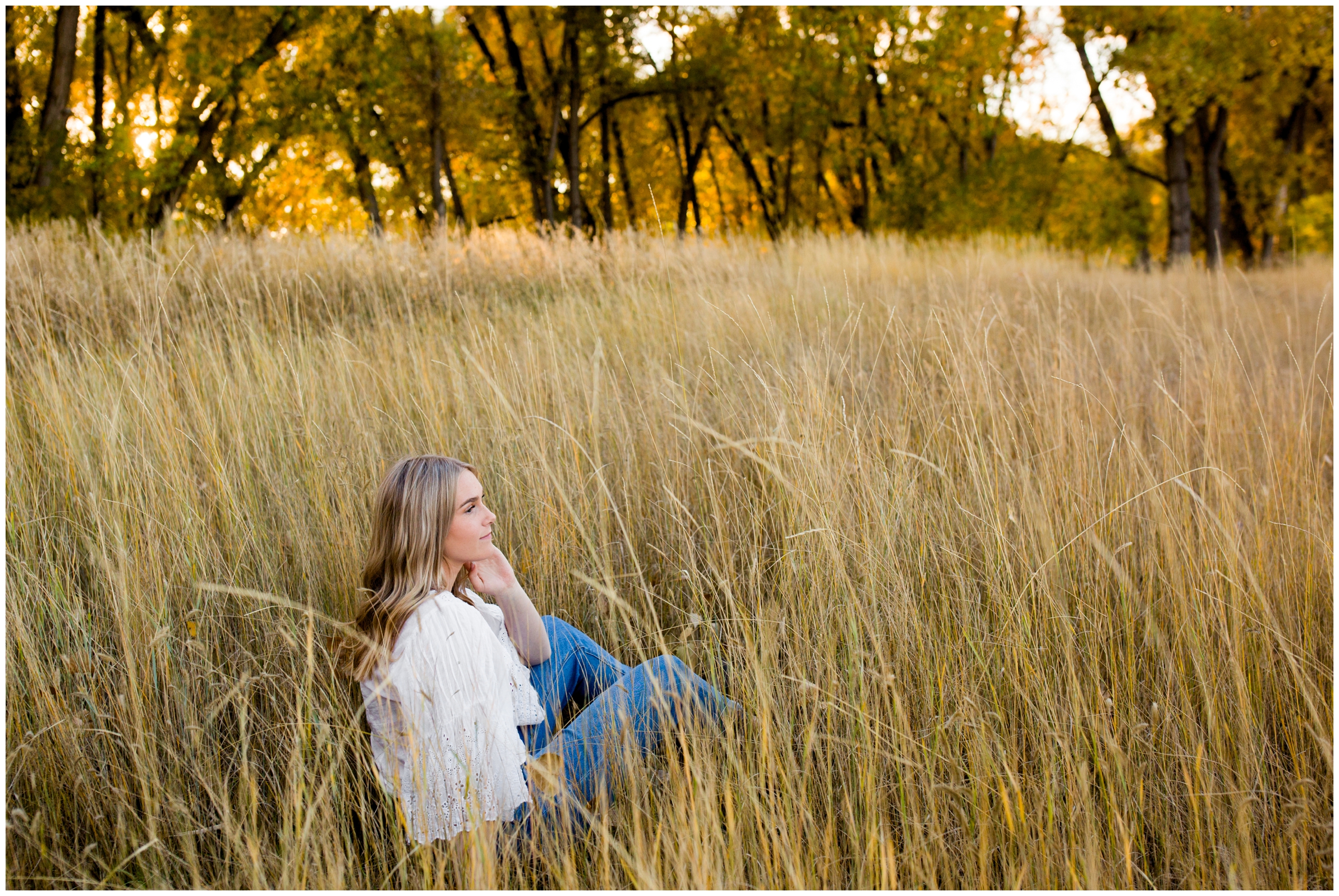 teen sitting in a field during Golden Ponds Longmont senior portraits 