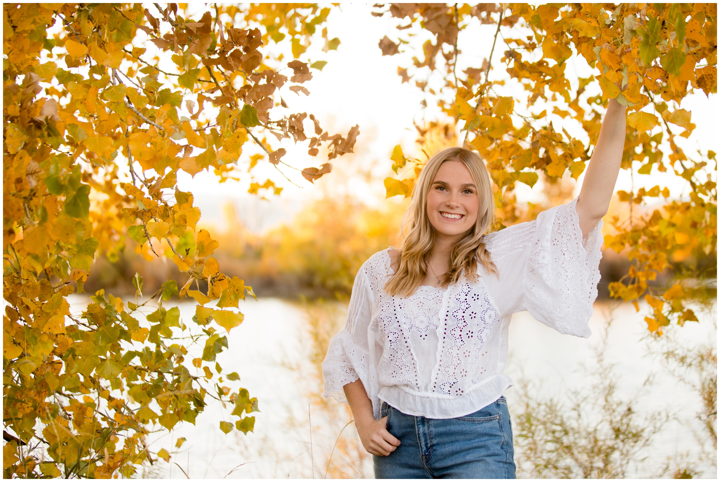 teen posing with fall foliage during Longmont senior pictures at Golden Ponds Nature Area 