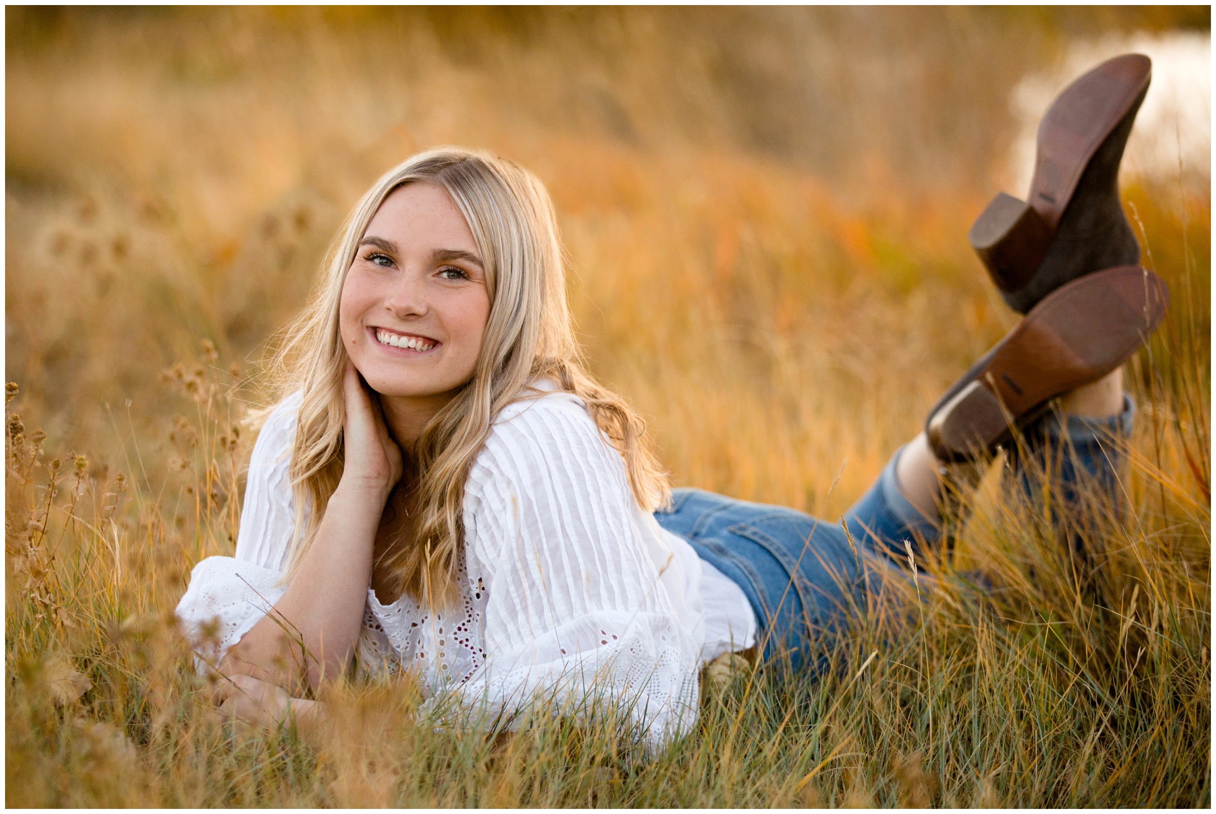 teen laying in golden field during Longmont Colorado senior photos 
