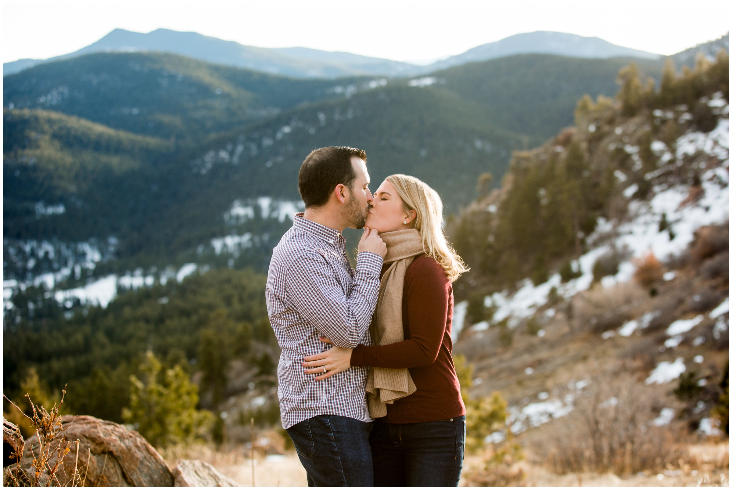 couple kissing with mountains in background during Denver engagement pictures 