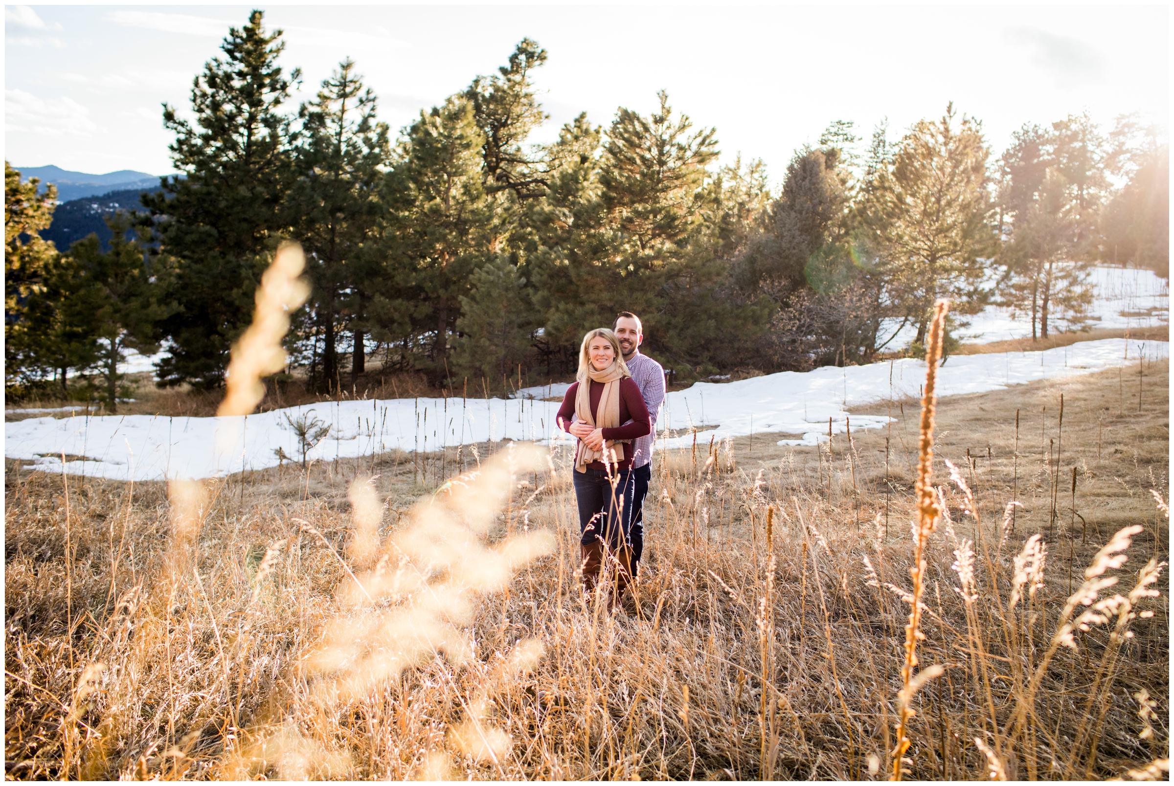 couple posing in a field during their Colorado winter engagement photos at Mt Falcon