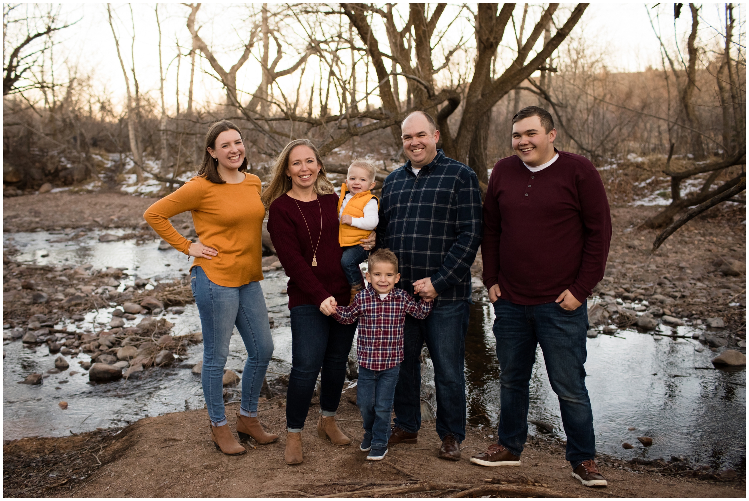 family posing next to river for fall family photography session