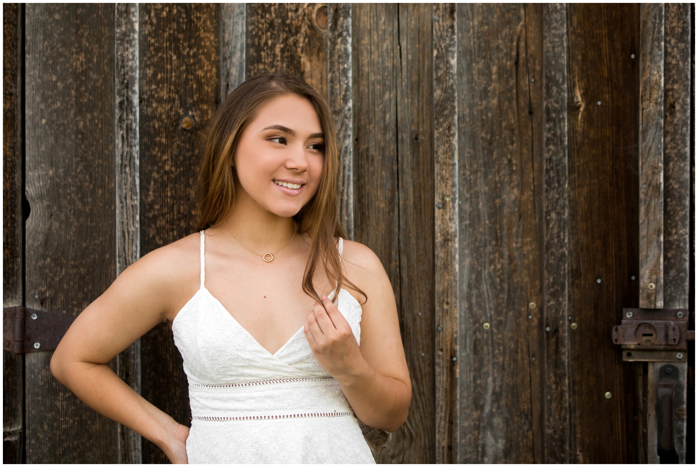 teen posing in front of rustic barn during Colorado ranch senior pictures in Longmont 