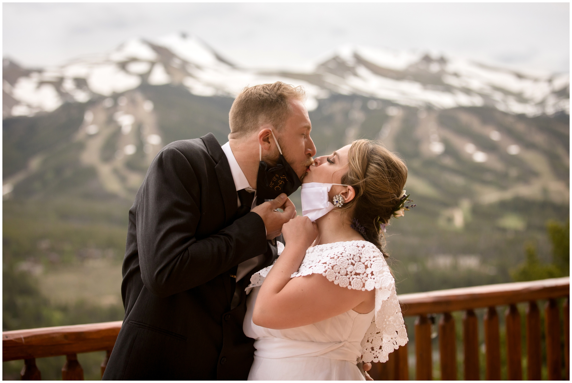 bride and groom pulling face masks down to kiss with mountains in background at covid micro wedding