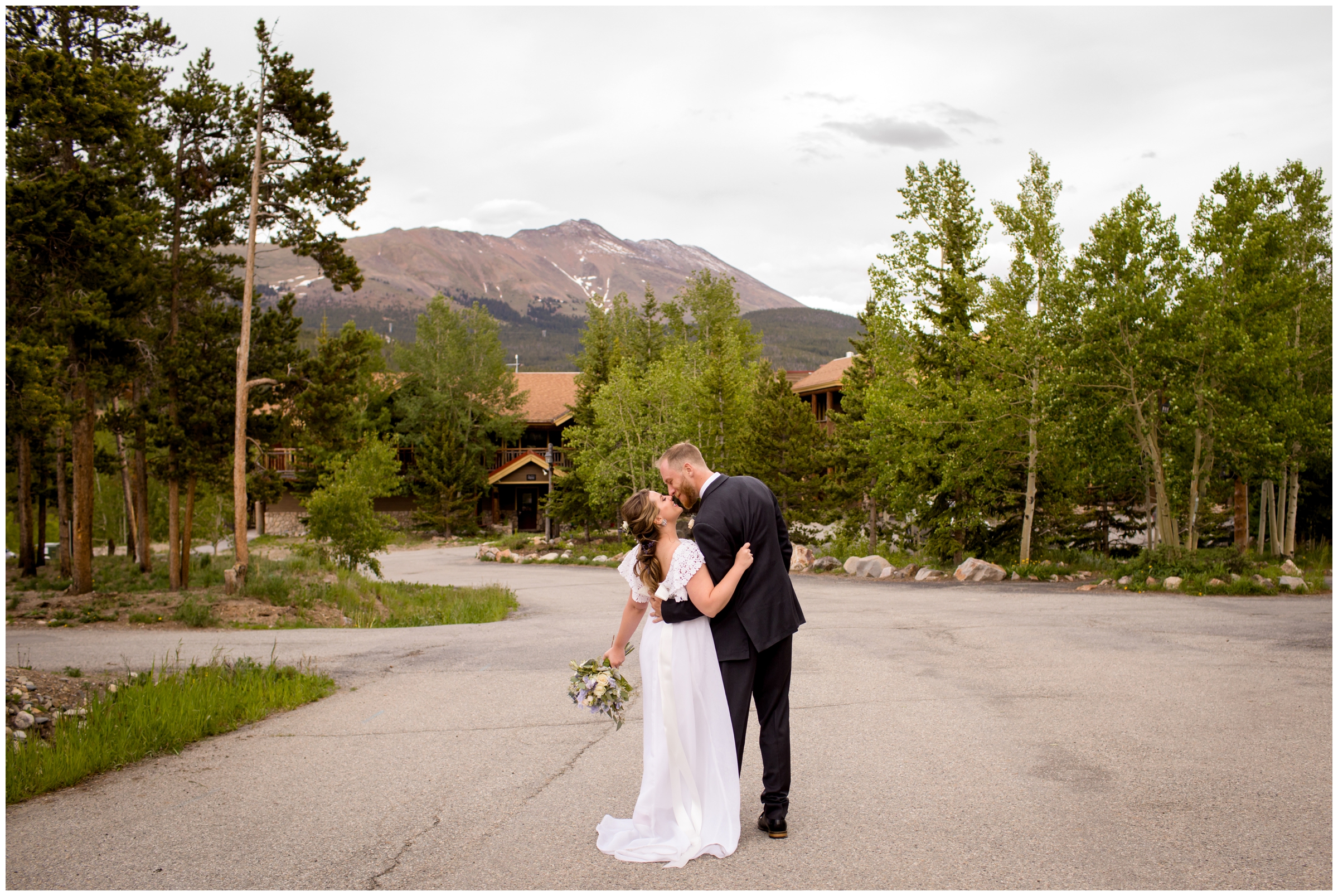 couple kissing with the lodge at Breckenridge in the background 