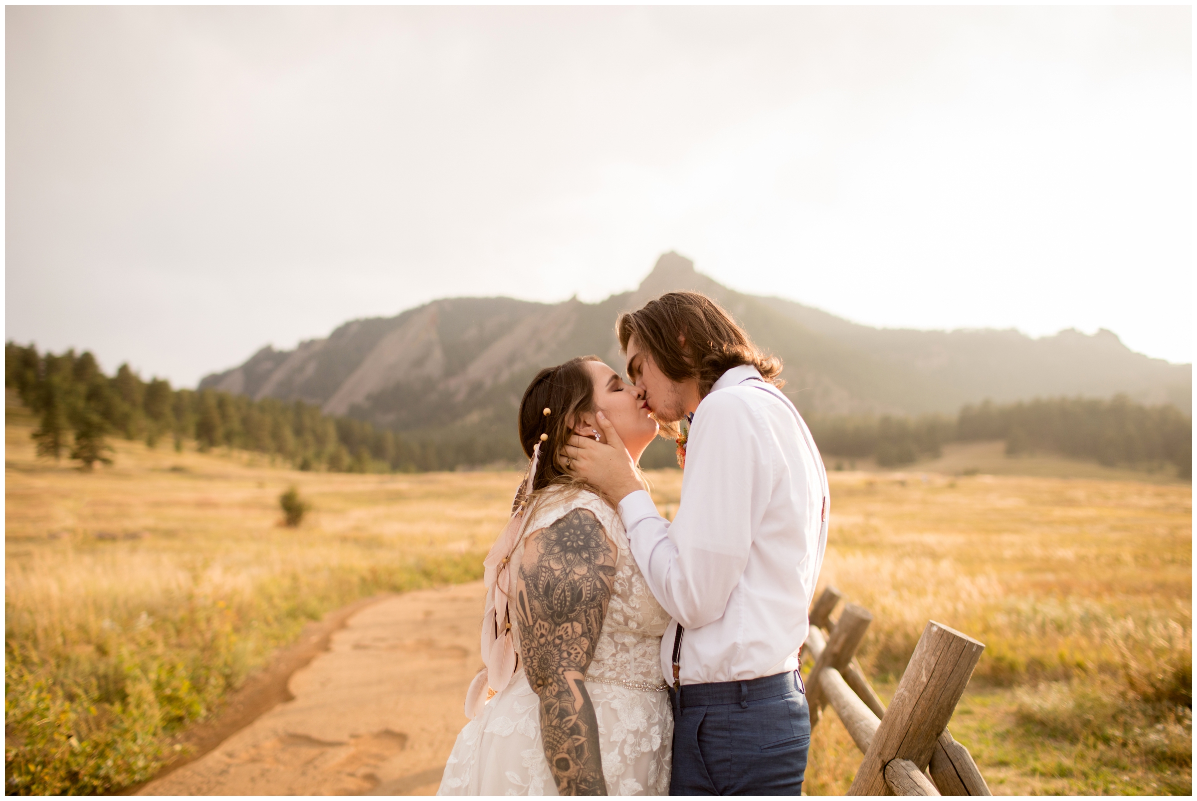 couple kissing with flatirons in background at fall Boulder Colorado boho wedding
