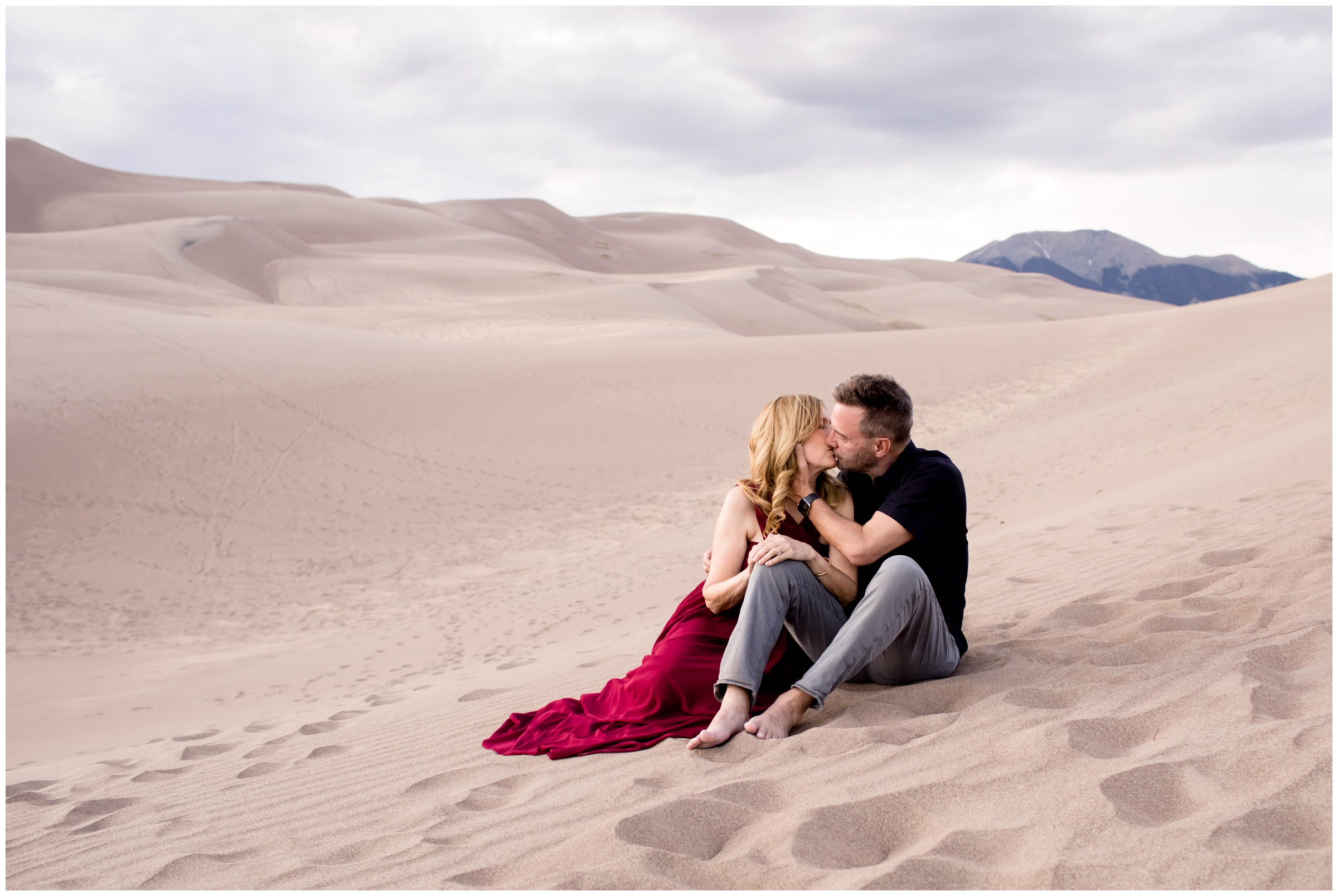 couple sitting on sand dunes during Colorado couple's photos