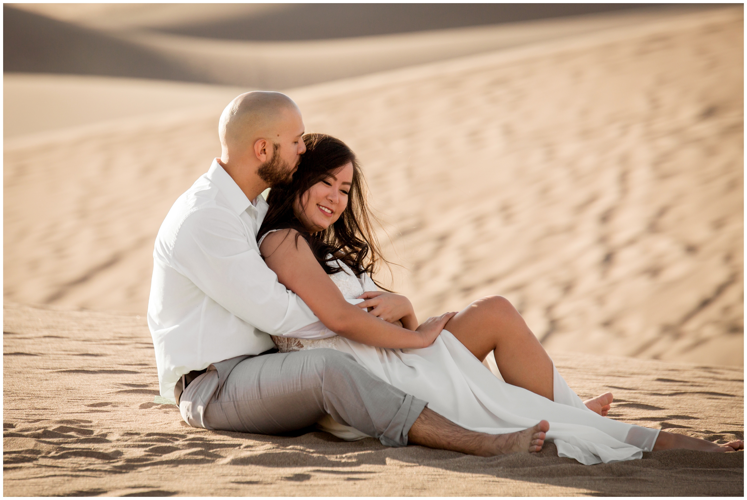 couple cuddling in the sand during sand dunes elopement photography session in Colorado 