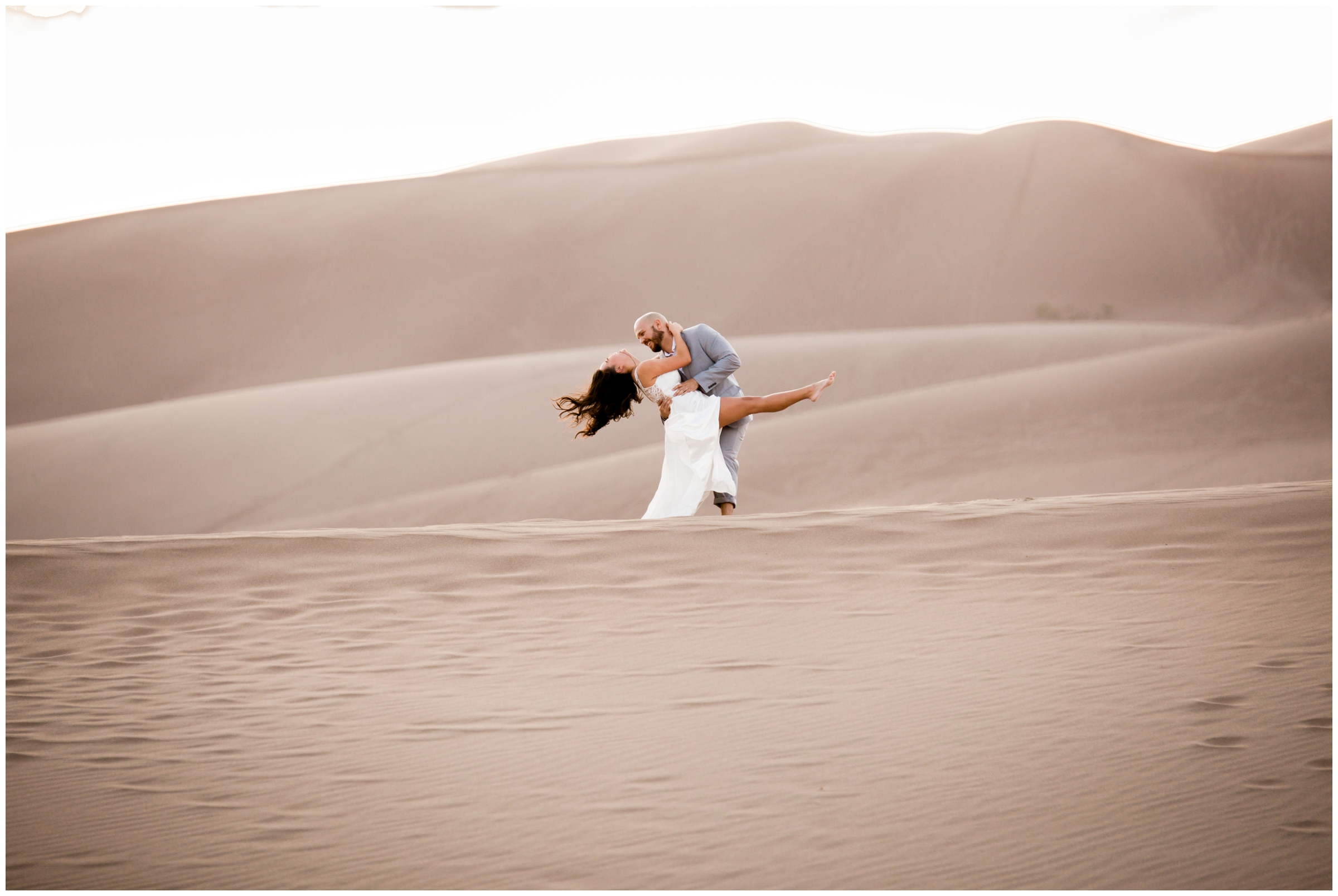 groom dipping bride during Colorado sand dunes elopement pictures 