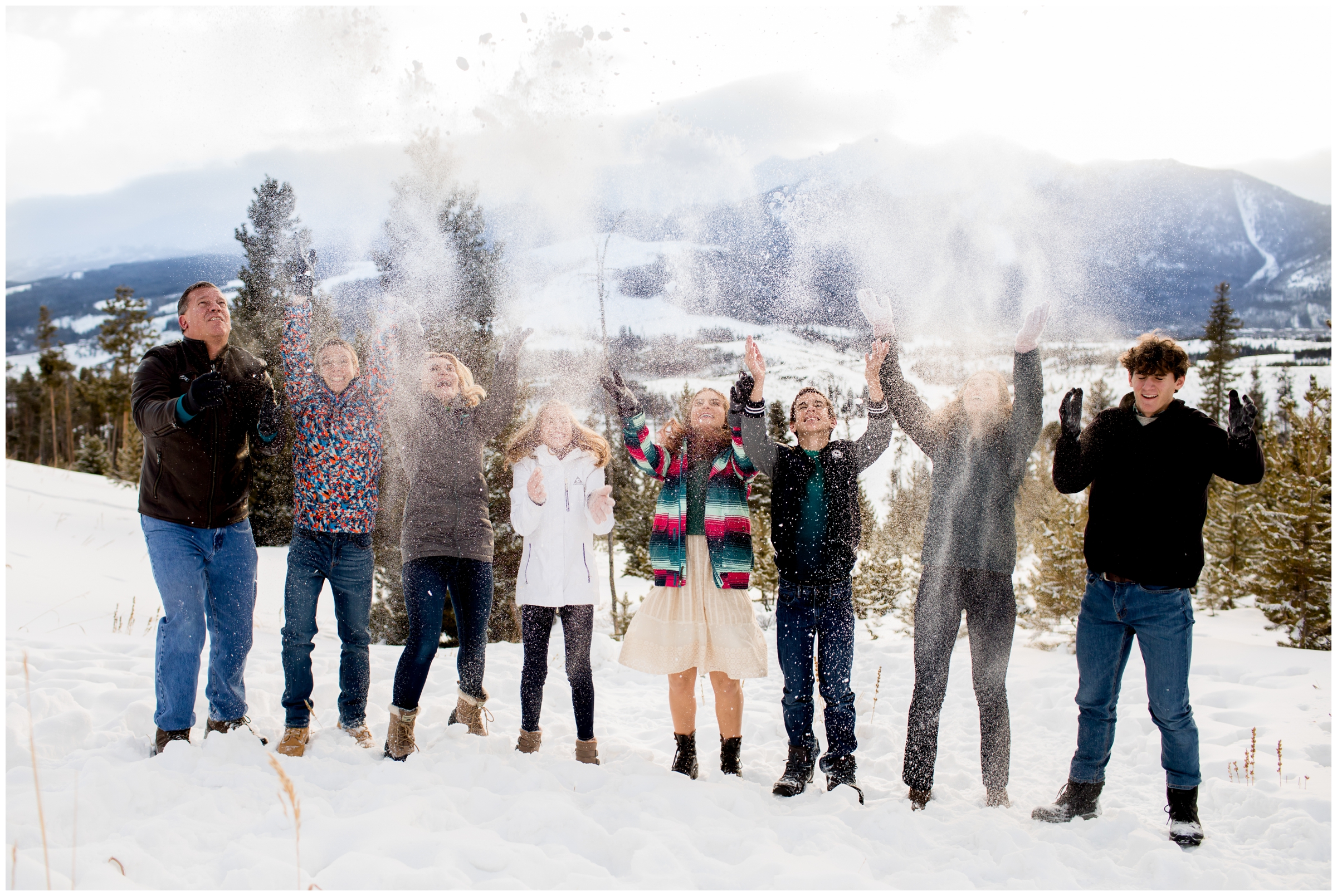 family throwing snow during unique winter family photography session in Breckenridge 
