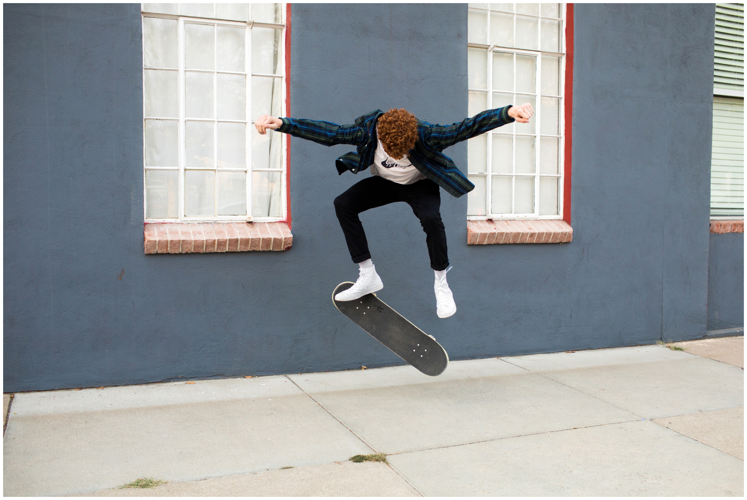Teen boy doing tricks on skateboard during Denver Colorado urban senior photography session 