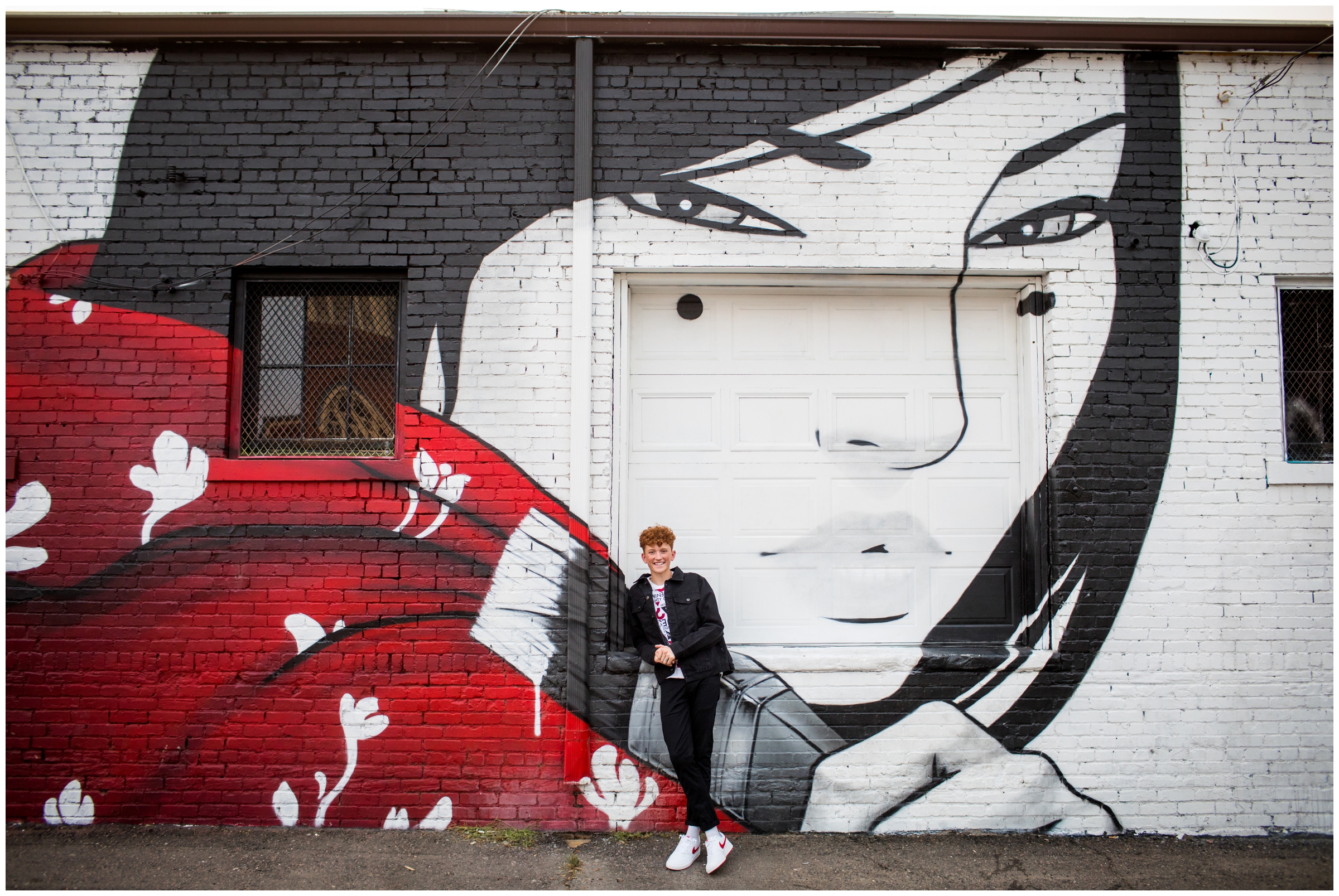 teen guy posing against wall mural during urban Colorado senior pictures 