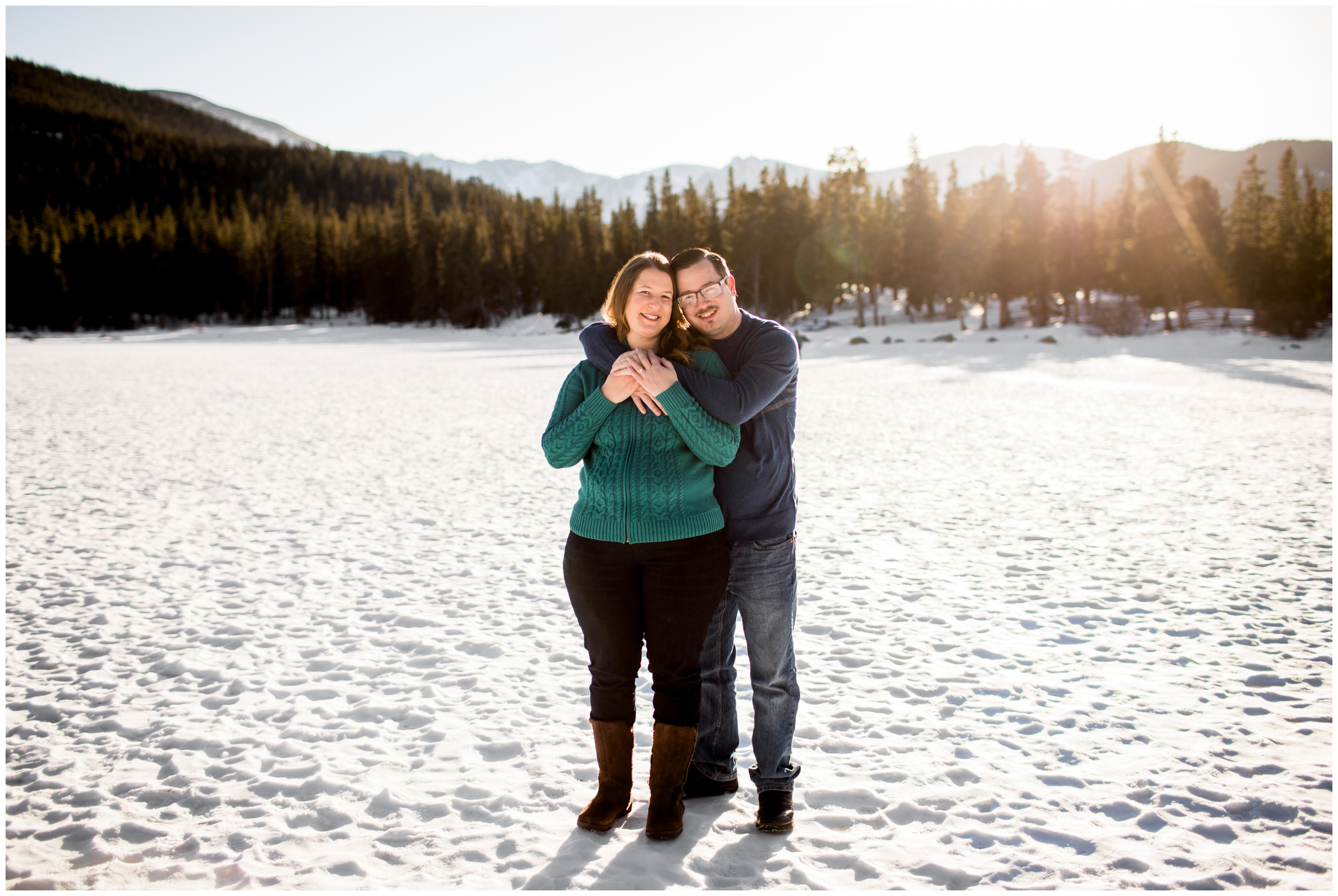 couple posing on frozen lake during Colorado winter engagement pictures 