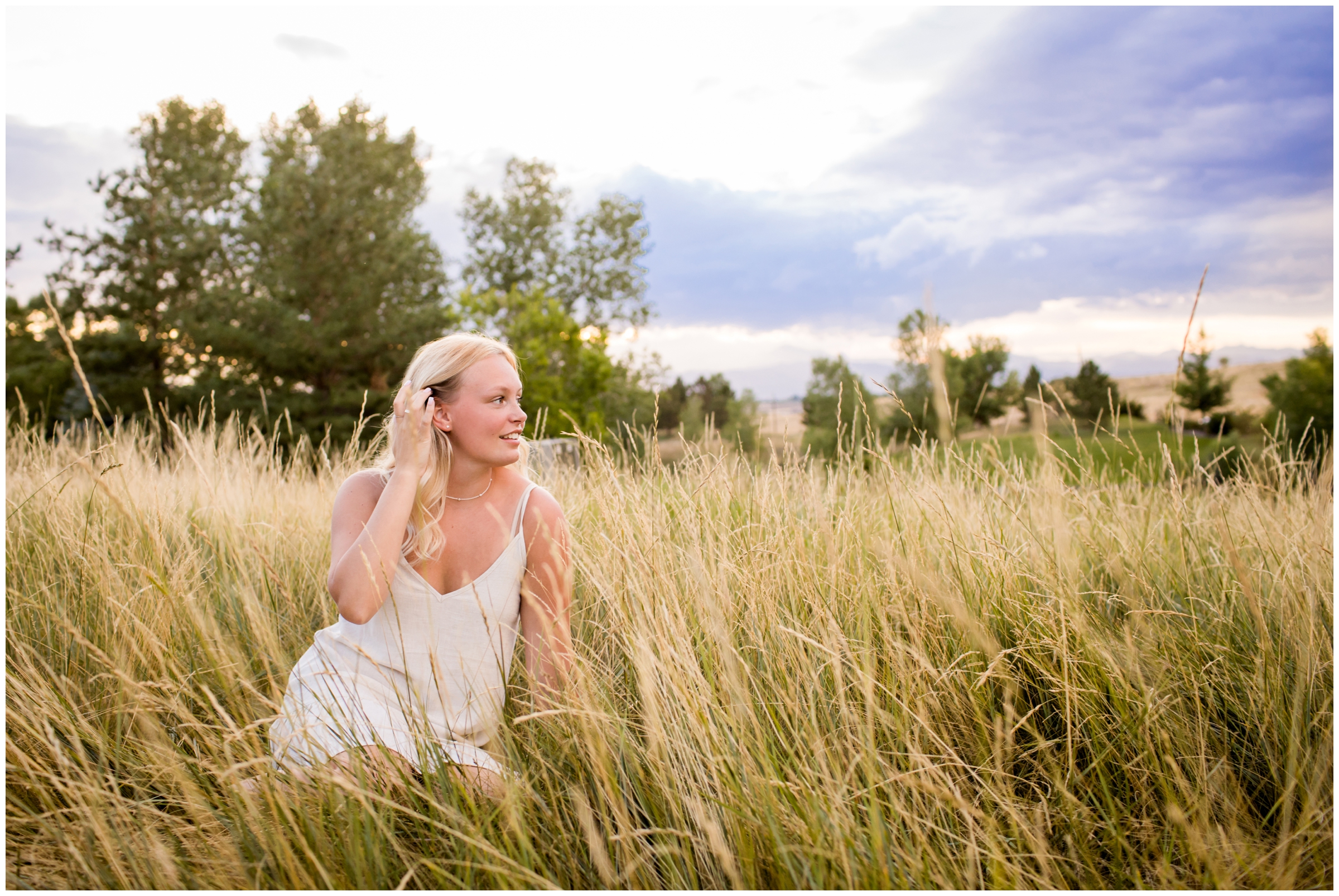 teen girl sitting in field of golden grasses at Erie Colorado high school senior pictures 