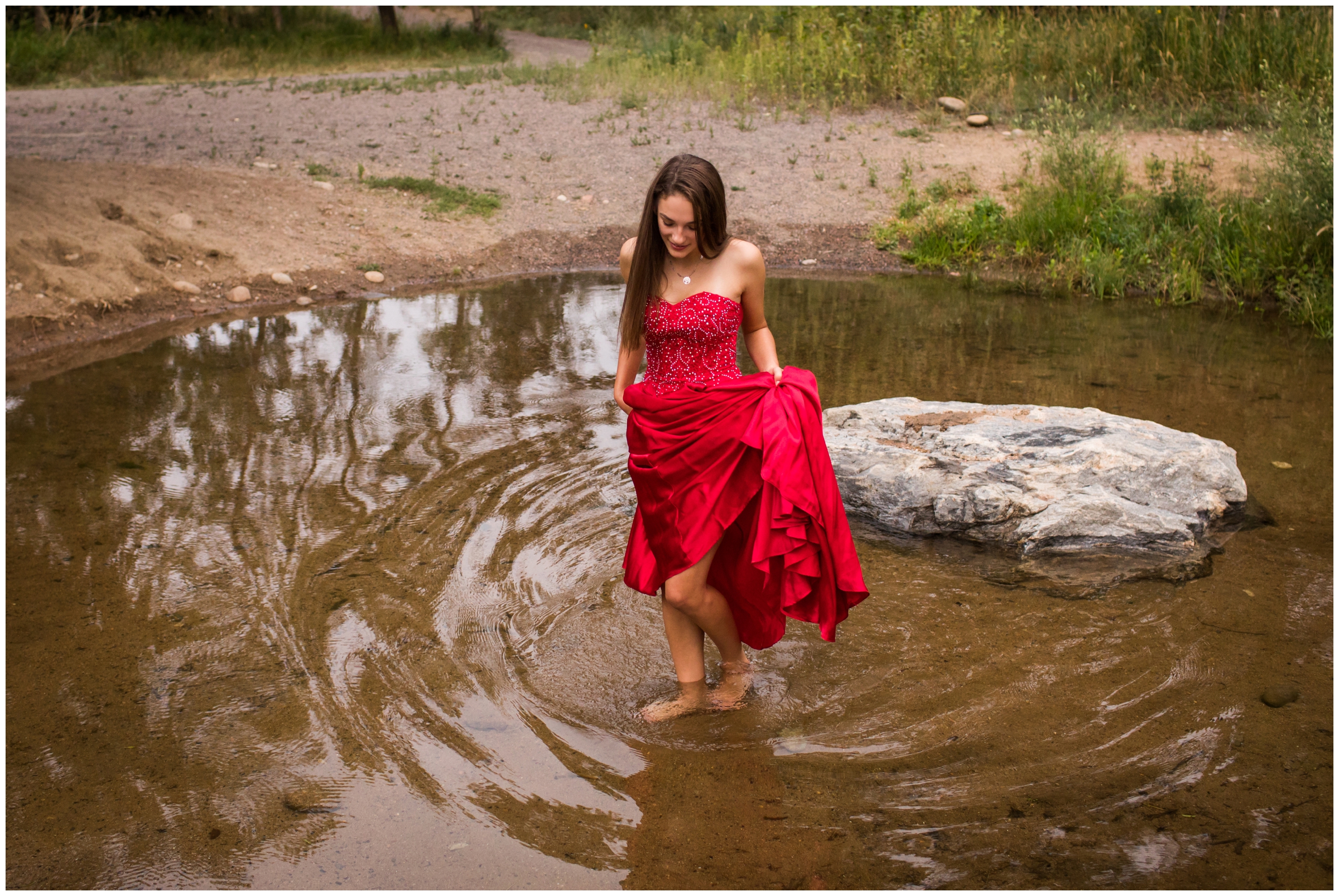 teen girl walking through river in prom dress during unique Colorado mountain senior portraits 