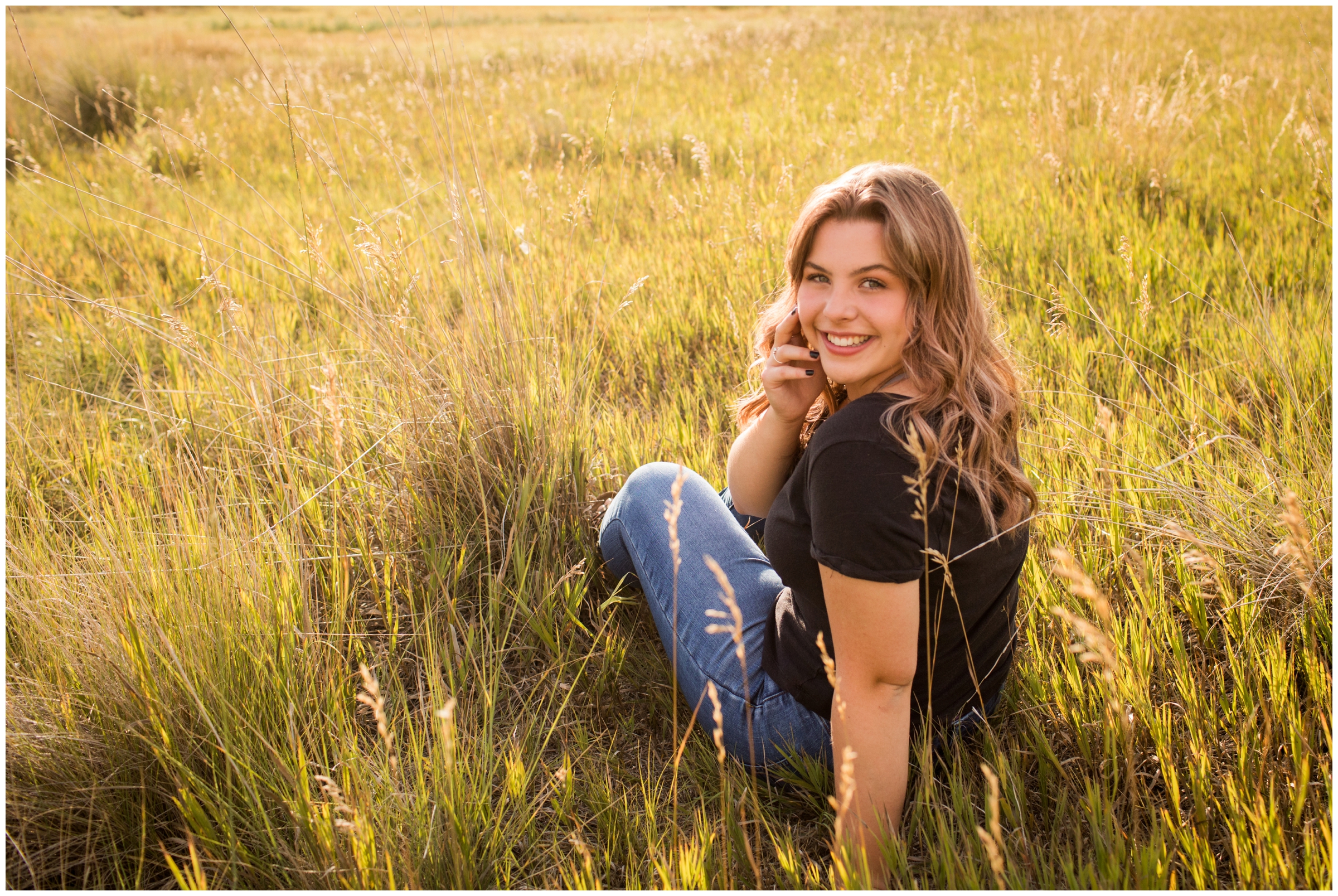 teen sitting in grass during Colorado senior portraits in longmont 